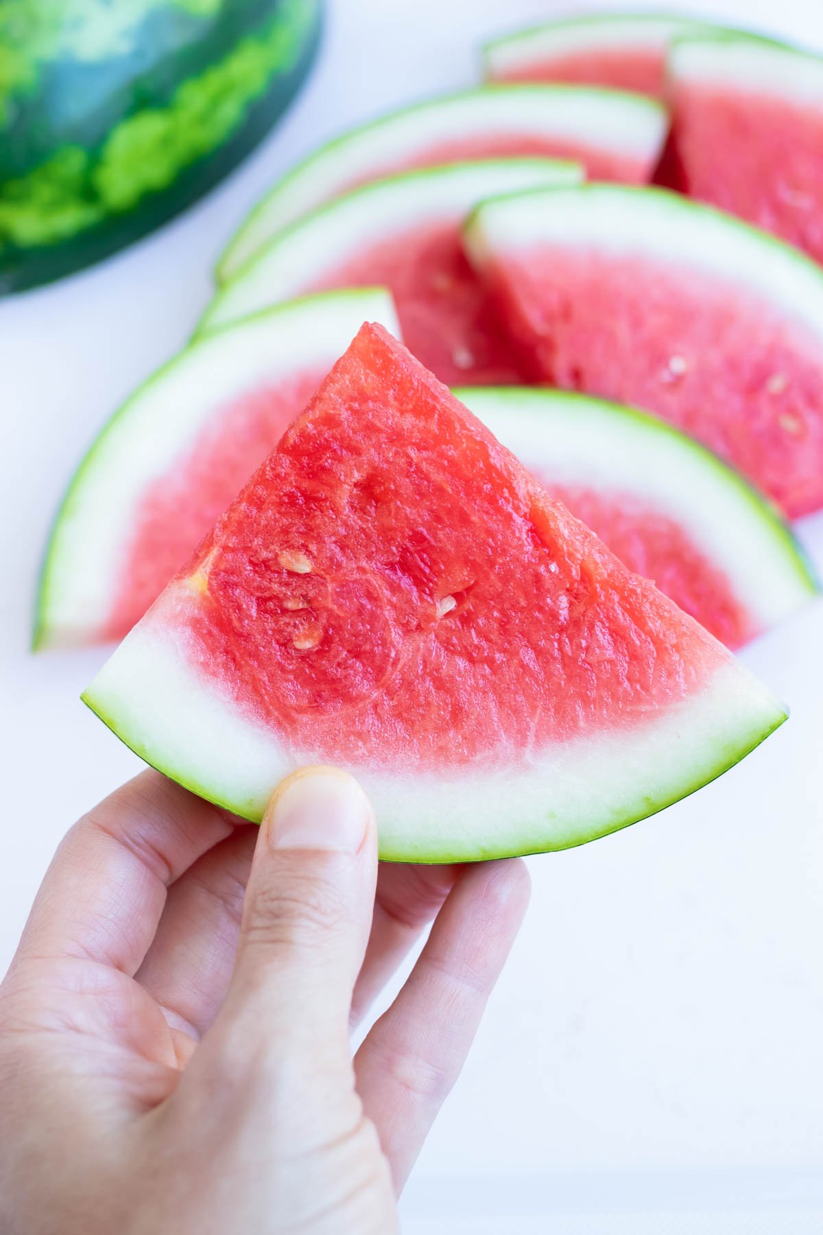 Holding up a slice of watermelon