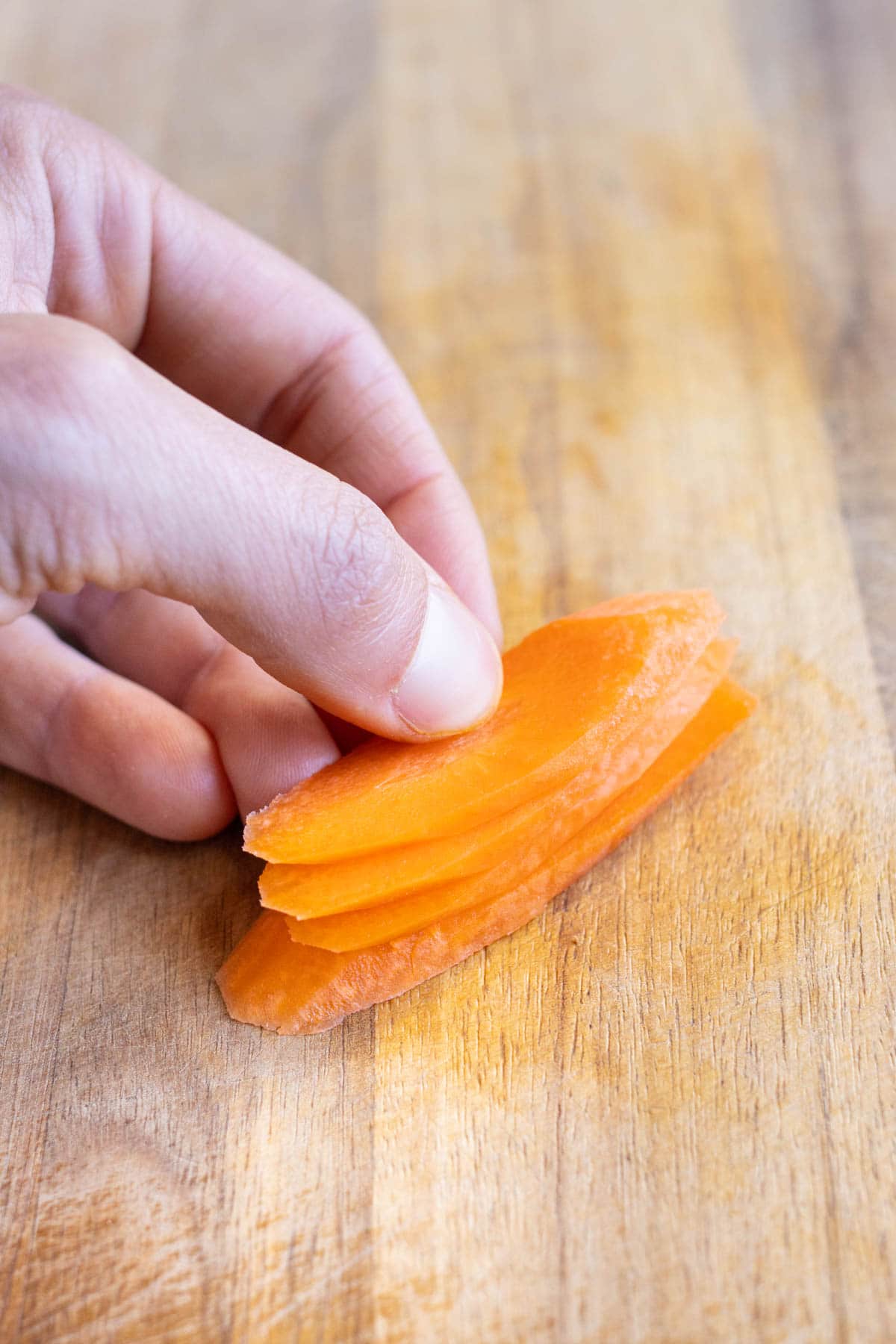 Carrot planks are stacked on top of each other before cutting into strips.