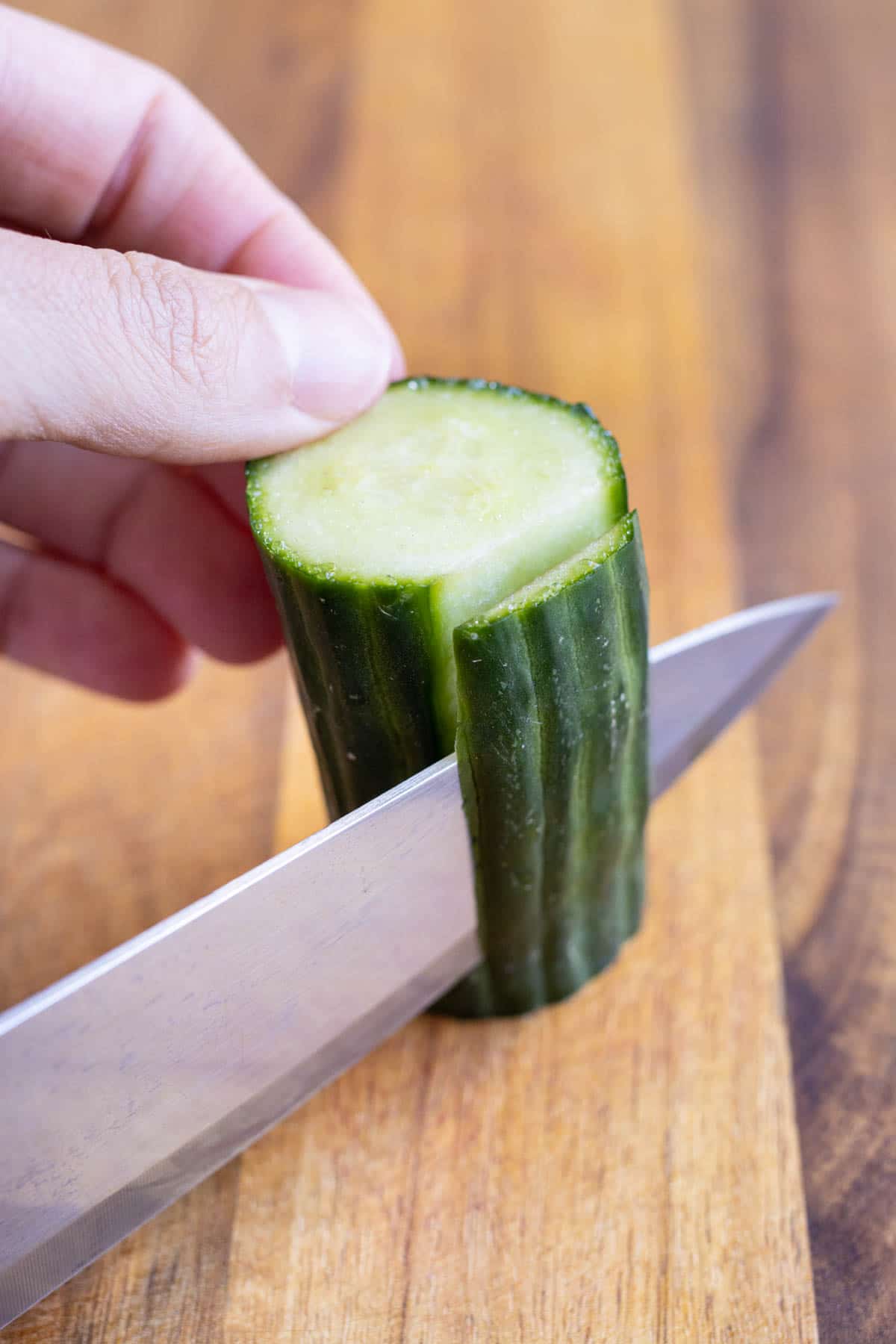 A cucumber is trimmed and peeled.