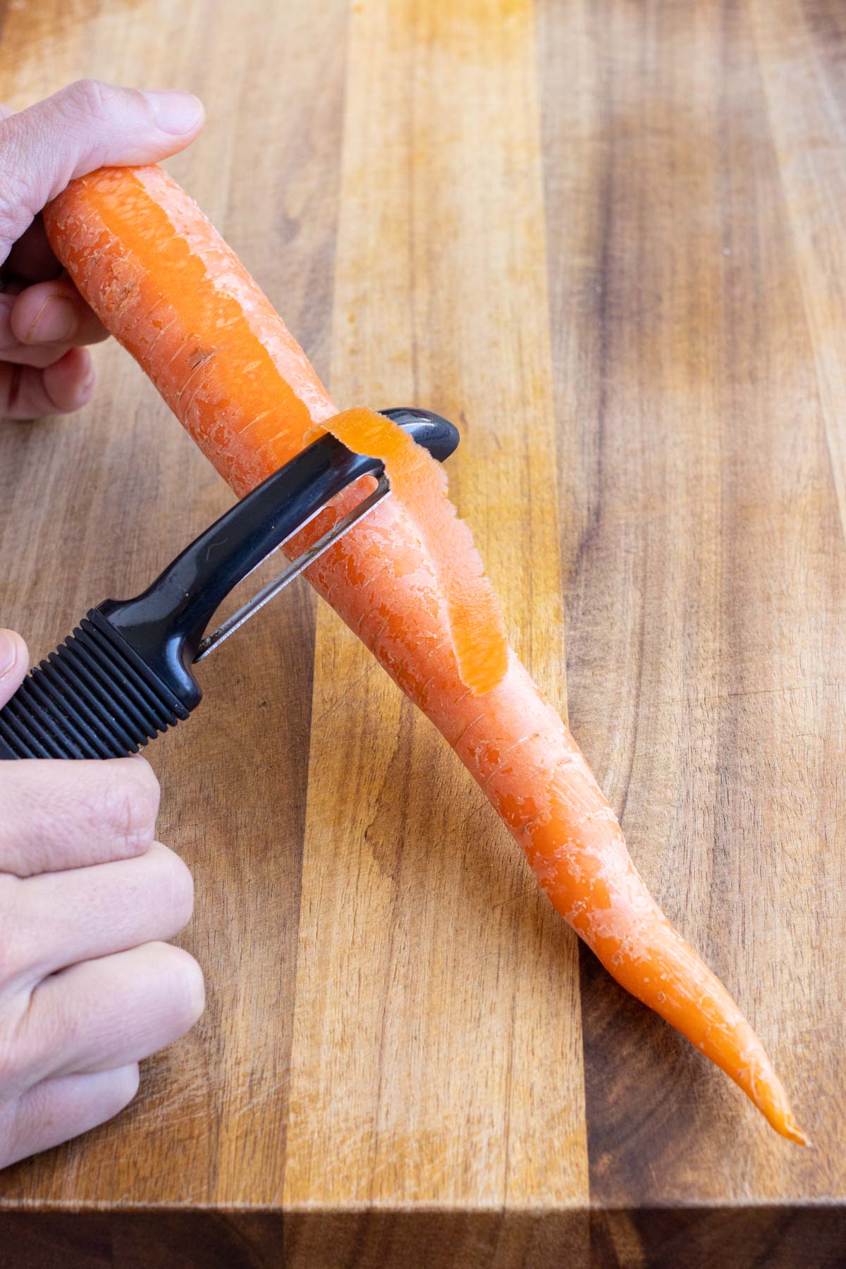 Carrots are peeled with a vegetable peeler.