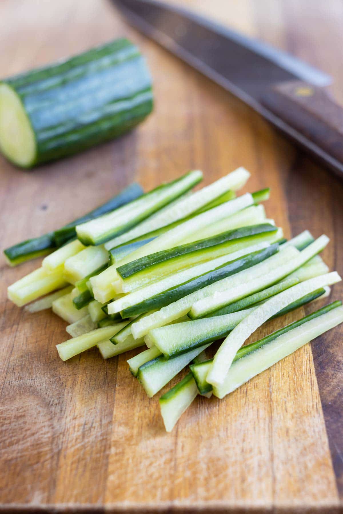 Cucumbers are cut Julienne style with a sharp knife.