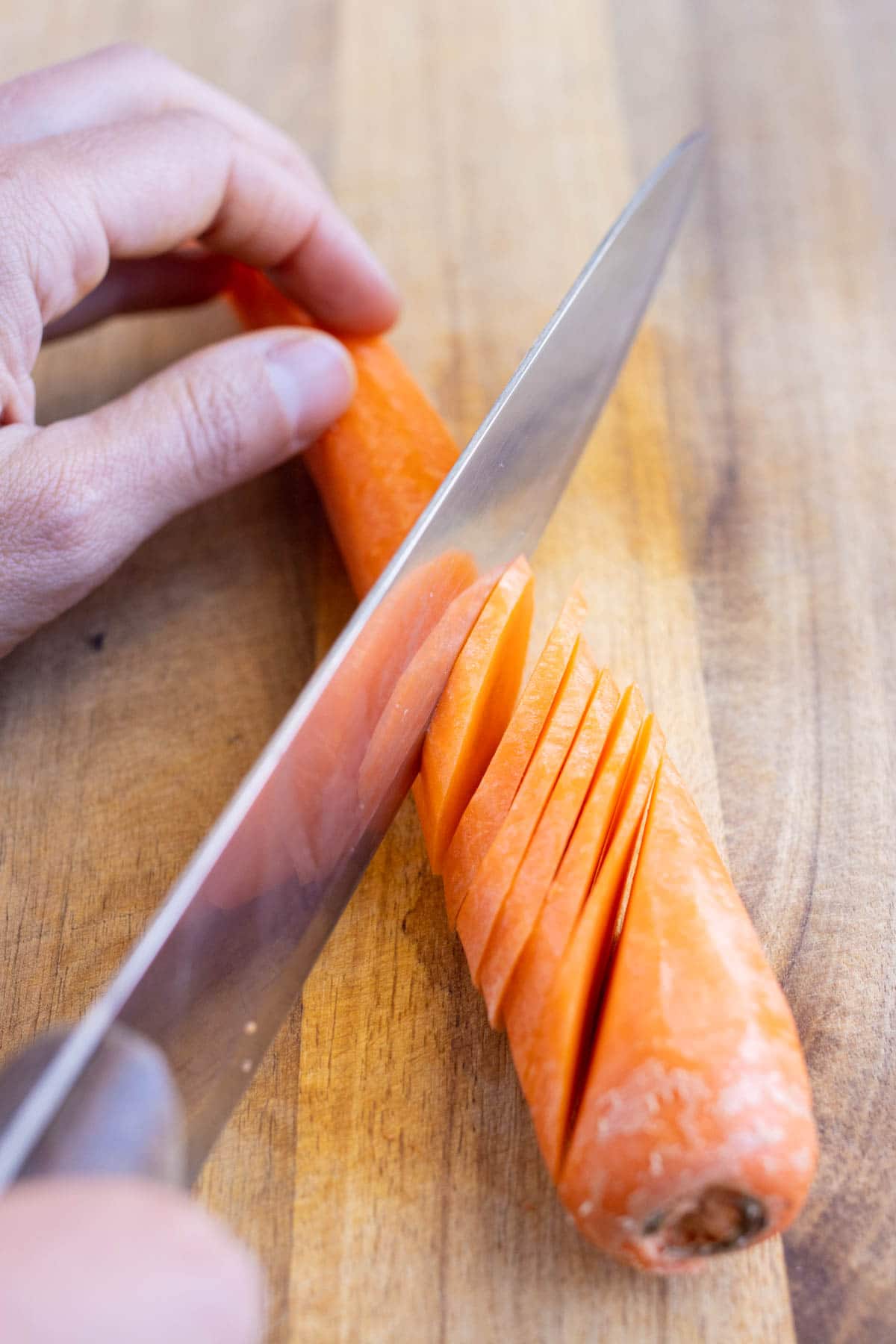 Carrots are cut at an angle before cutting into strips.