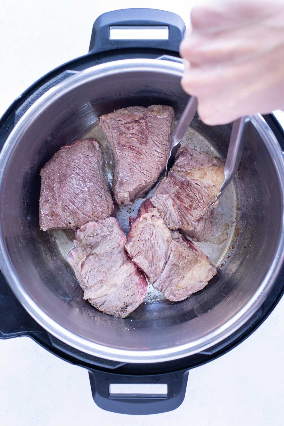 Chuck roast is seared in the instant pot.