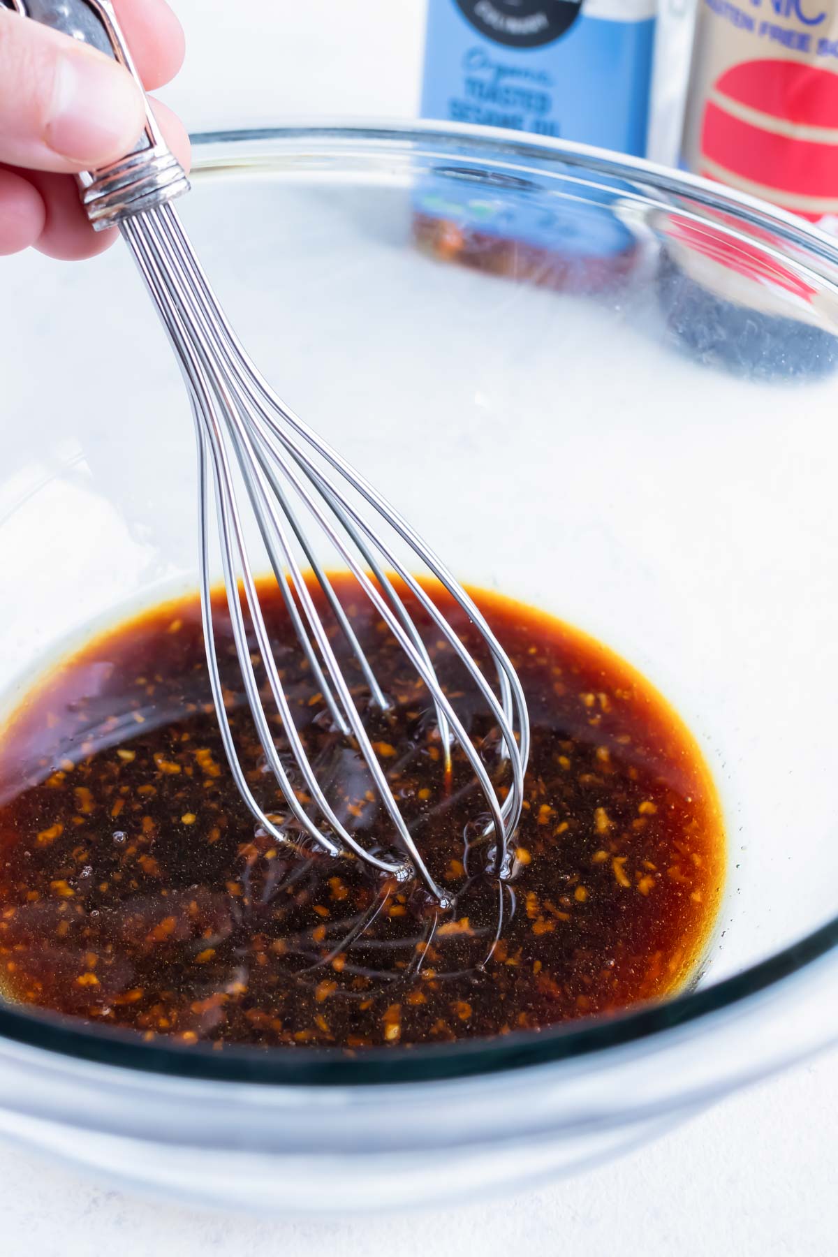Sauce ingredients are whisked together in a glass bowl.