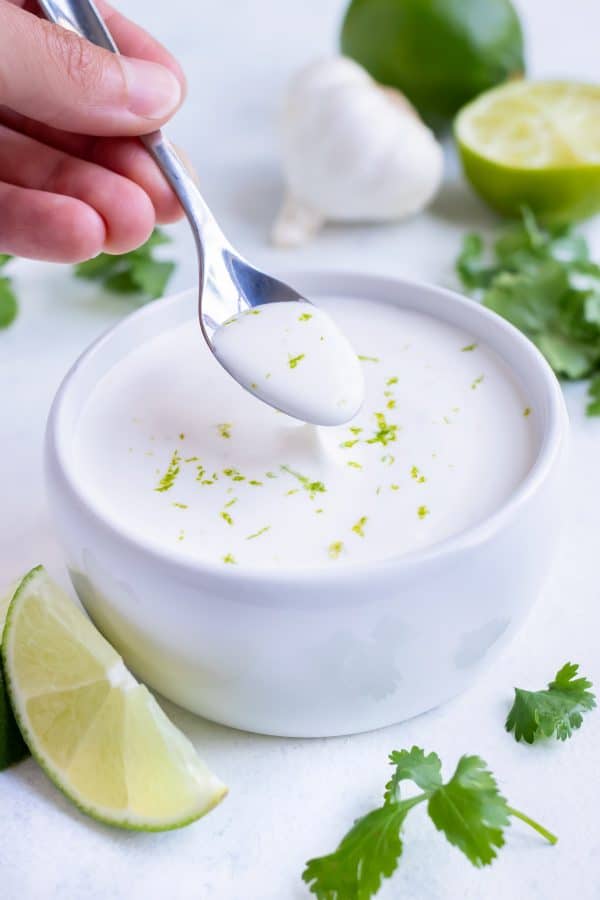 A spoon is used to serve this homemade lime crema.