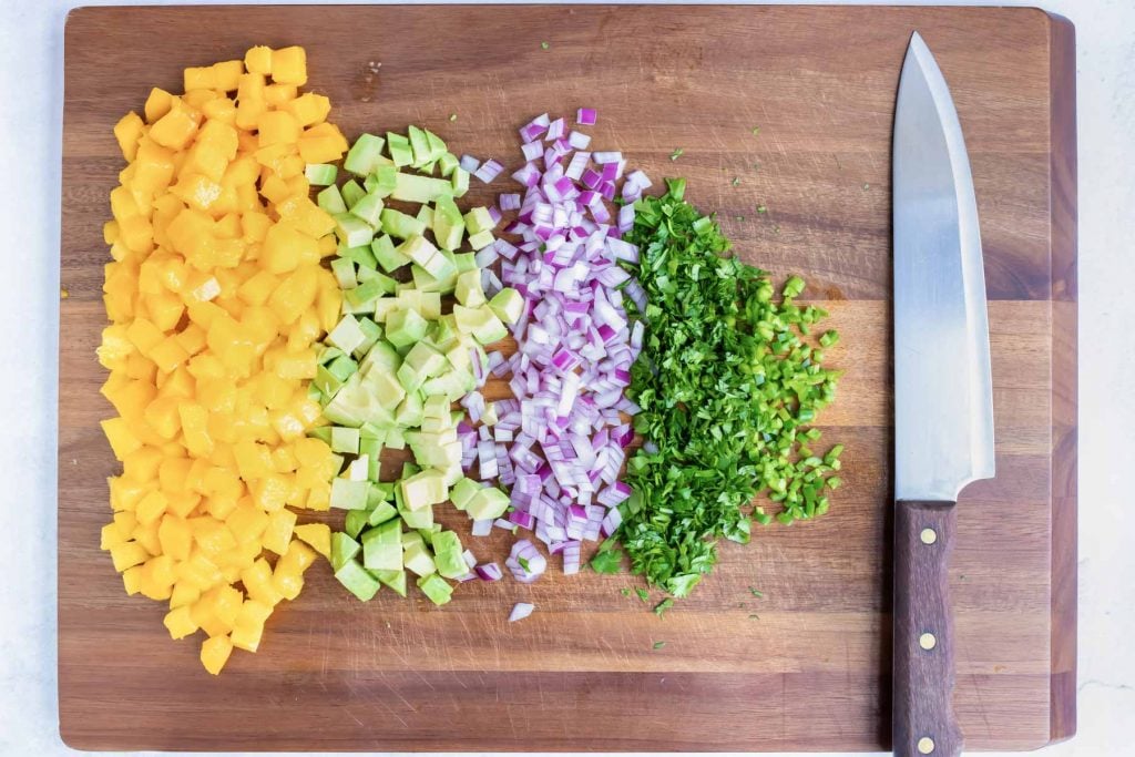 Finely diced mango, avocado, red onion, cilantro, and serrano peppers for an easy and fresh salsa recipe.