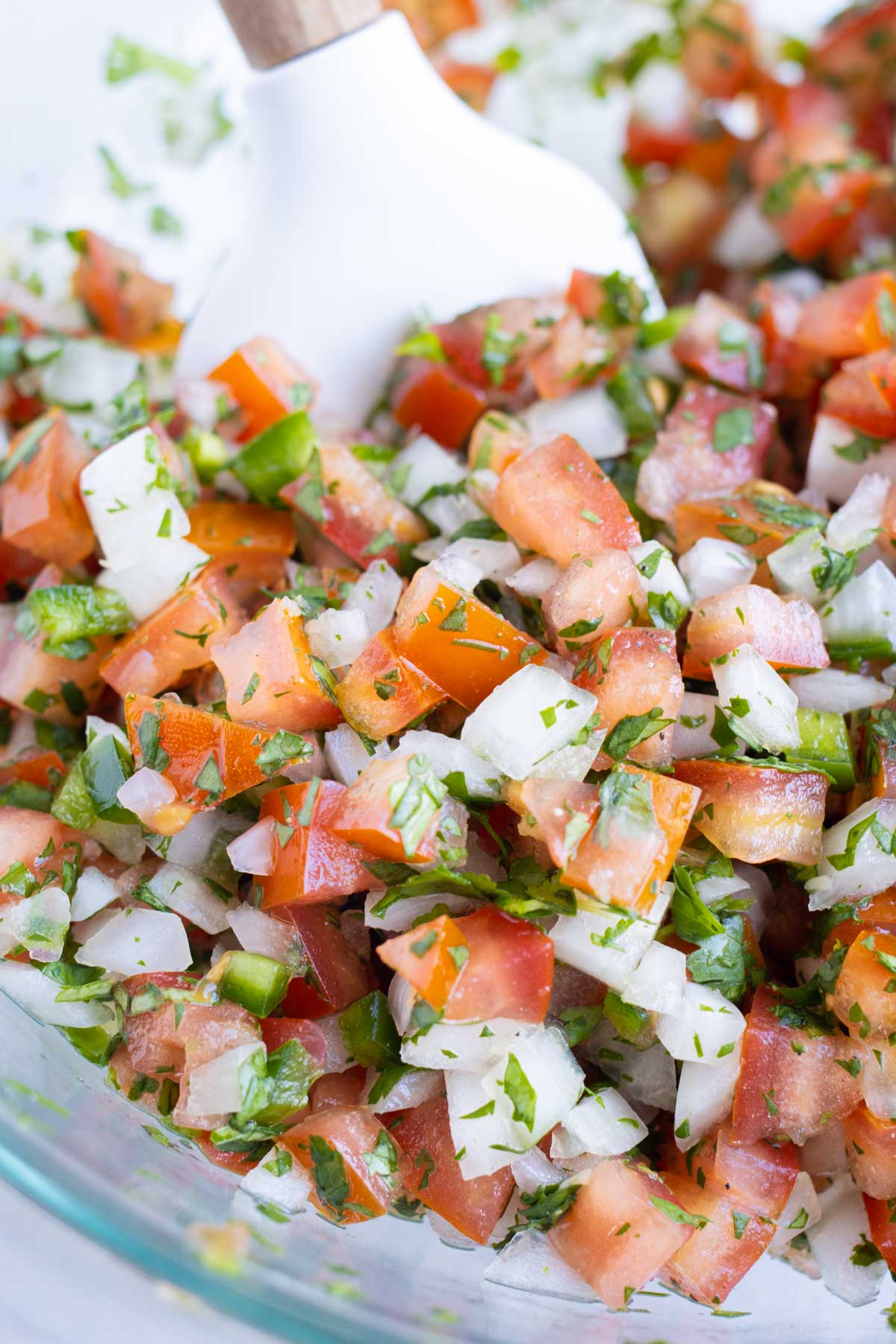 Prepared ingredients are mixed together with a spatula.