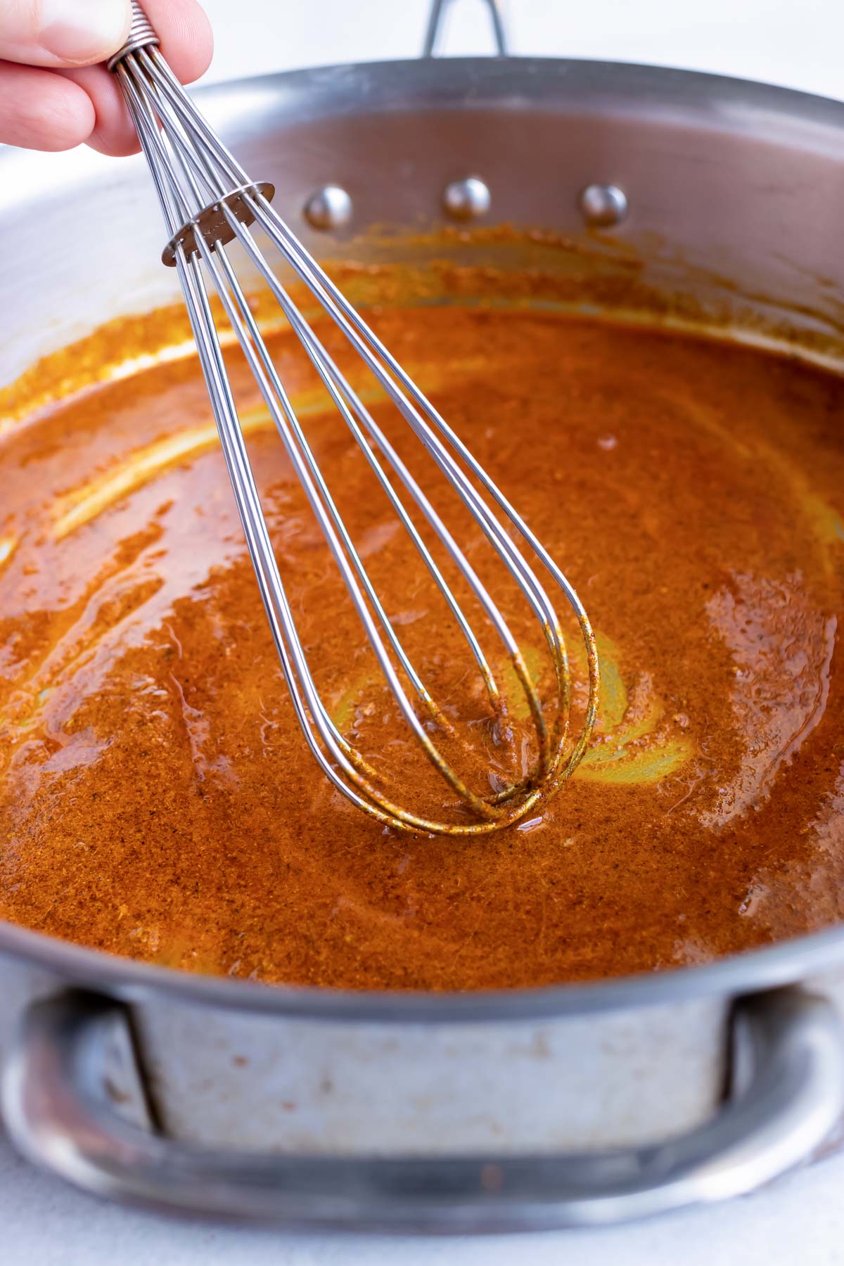 Whisking flour, oil, and seasonings for a roux.