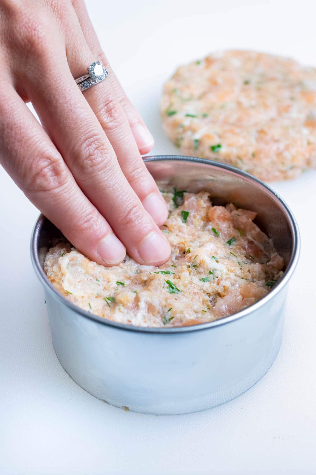 The salmon mixture is shaped into burger form.