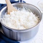 A wooden spoon is used to serve sticky rice.