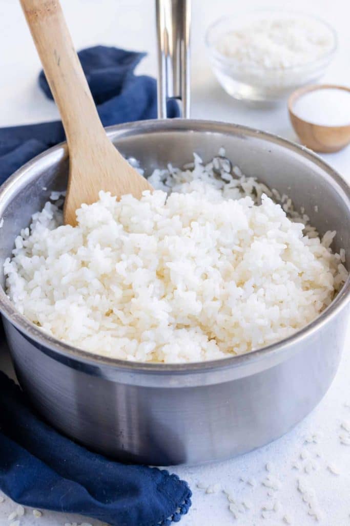 A pot is shown on the counter full of homemade sushi rice.