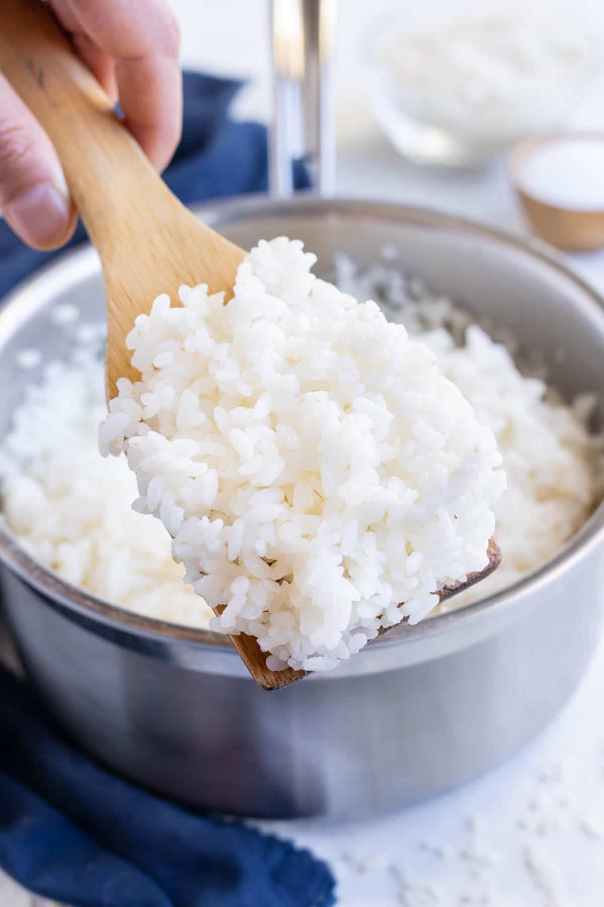 A wooden spatula is used to serve sticky rice.