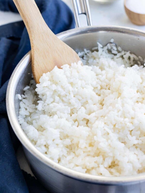 Homemade sushi rice is shown in a pot on the stove.