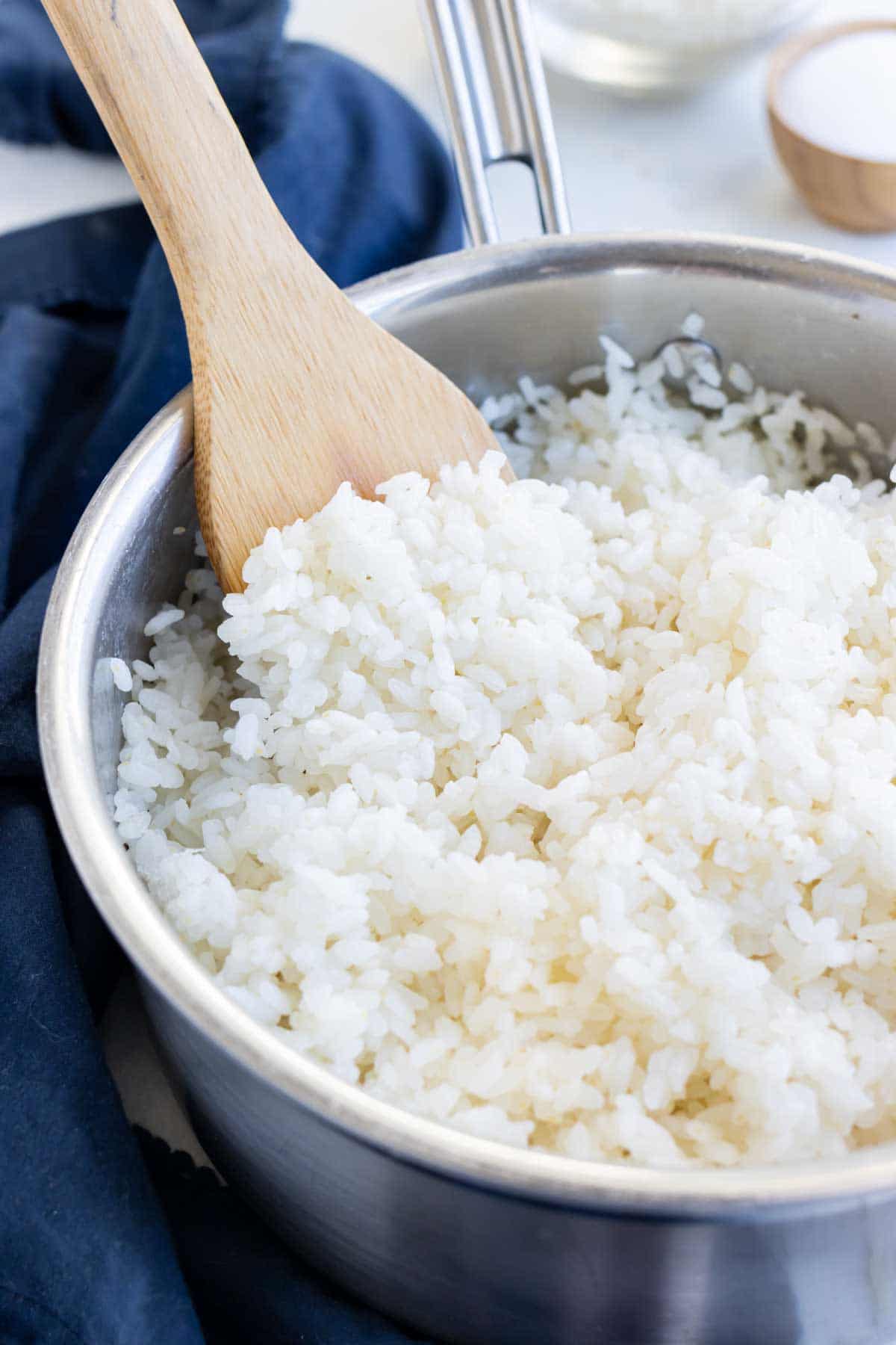 Homemade sushi rice is shown in a pot on the stove.