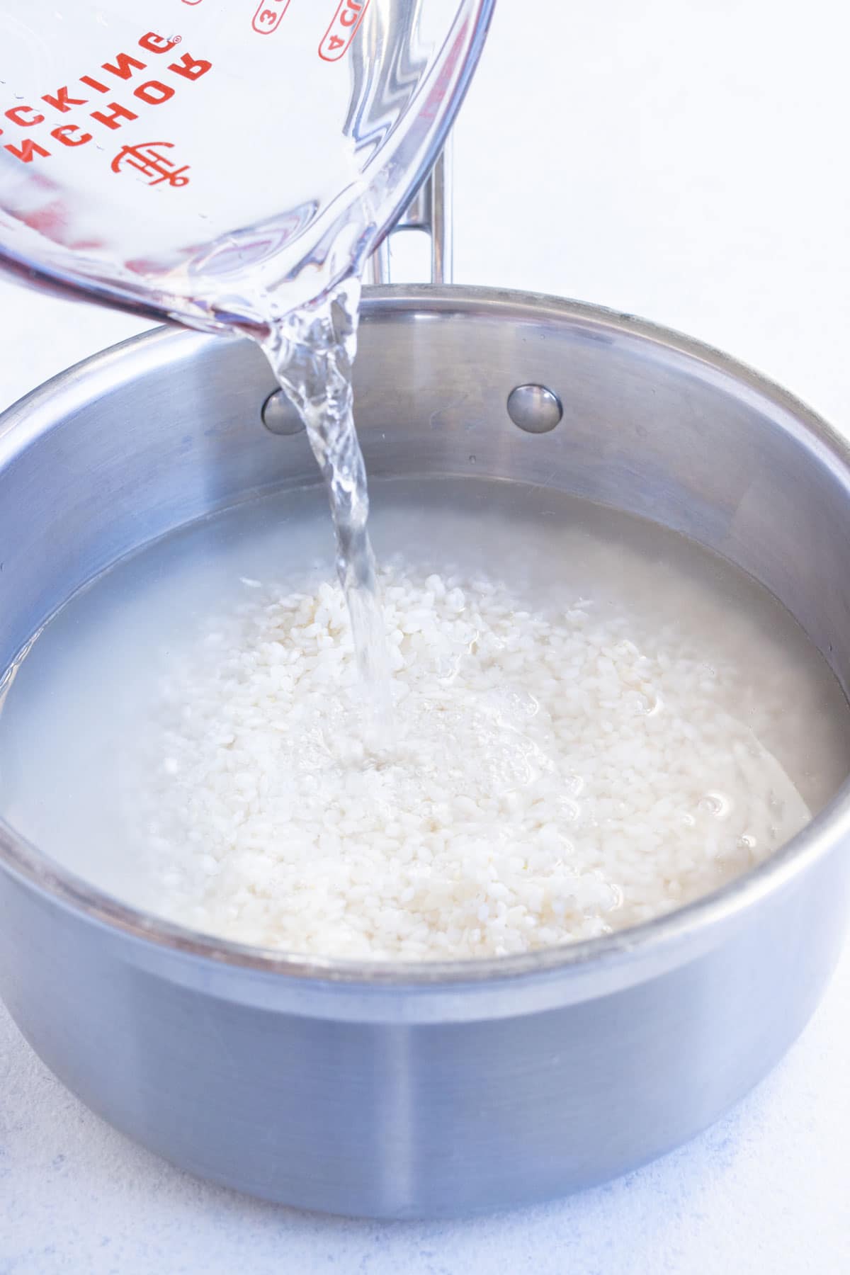 Water is poured into the pot with rice.