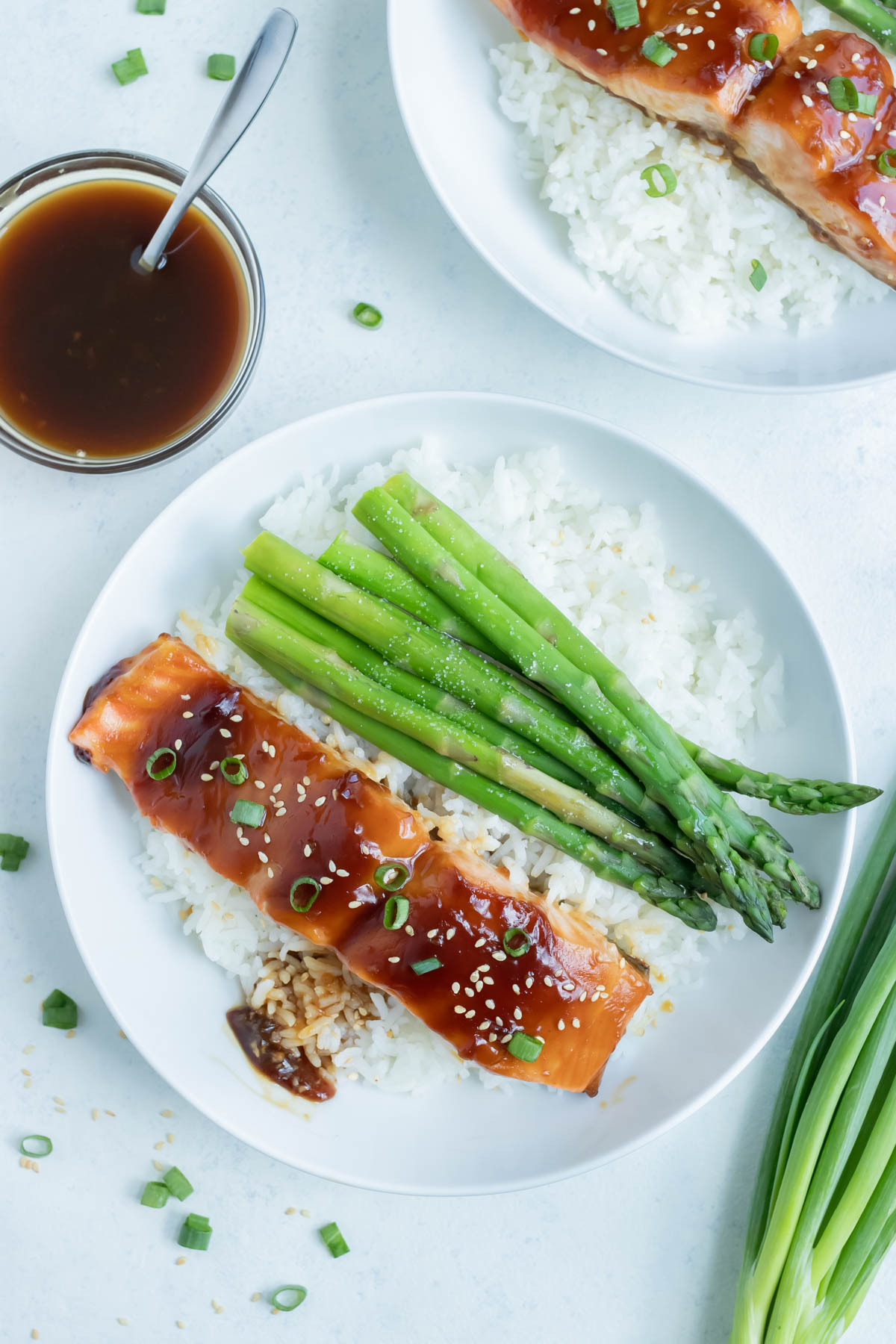 White rice, asparagus, and teriyaki salmon are served for a healthy dinner.