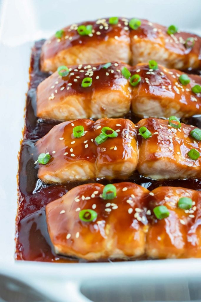 Healthy teriyaki salmon is served from a white baking dish.