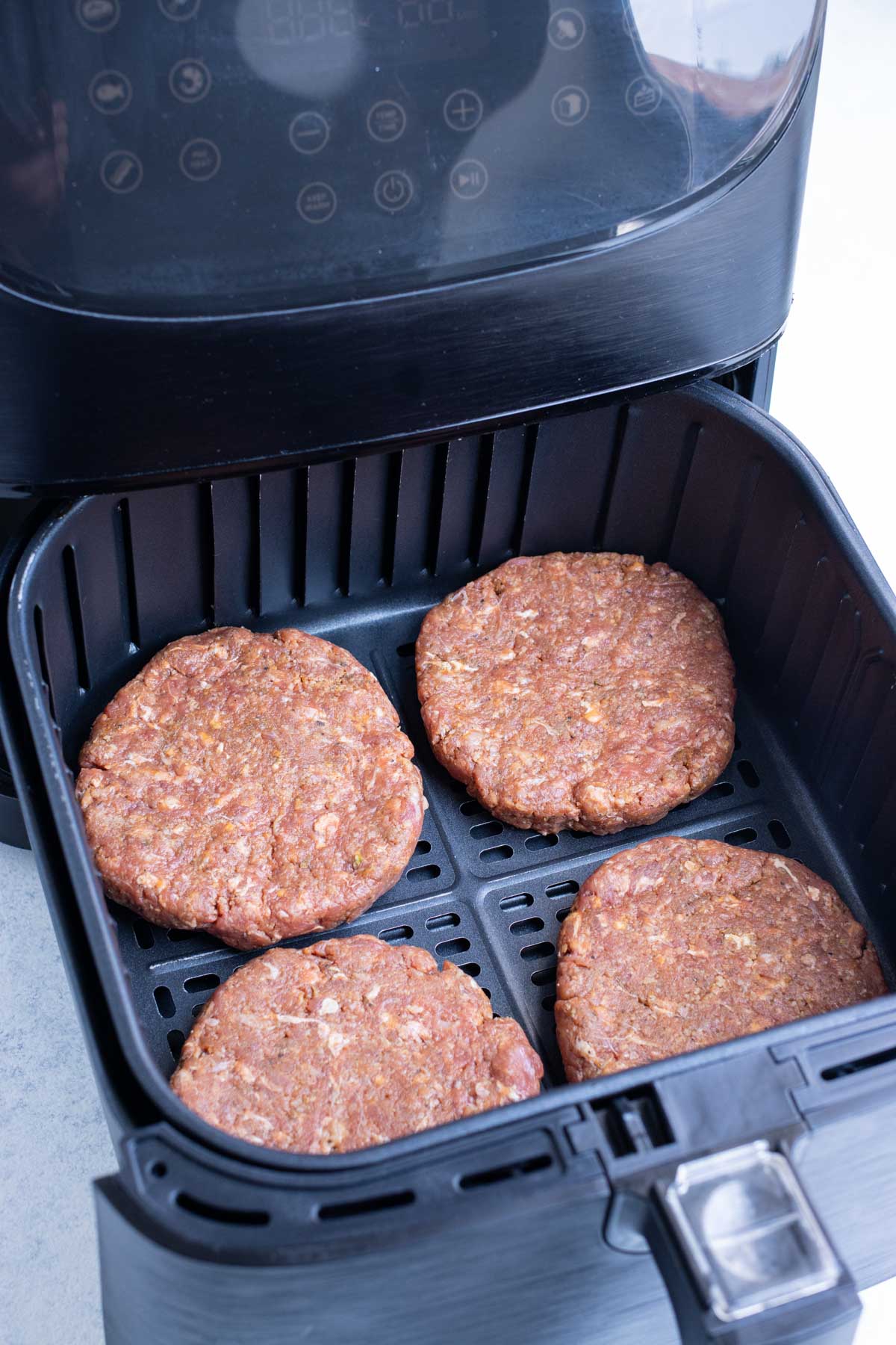 Four patties are added to the air fryer.
