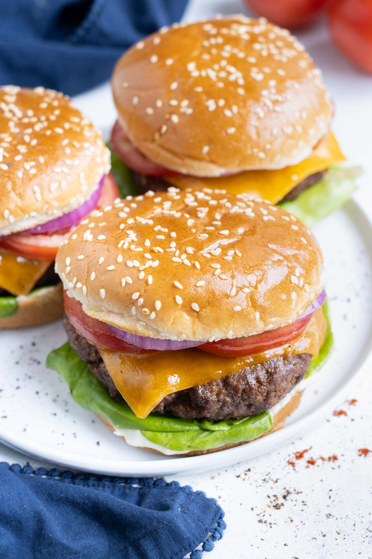 Three hamburgers are shown on a plate on the counter.