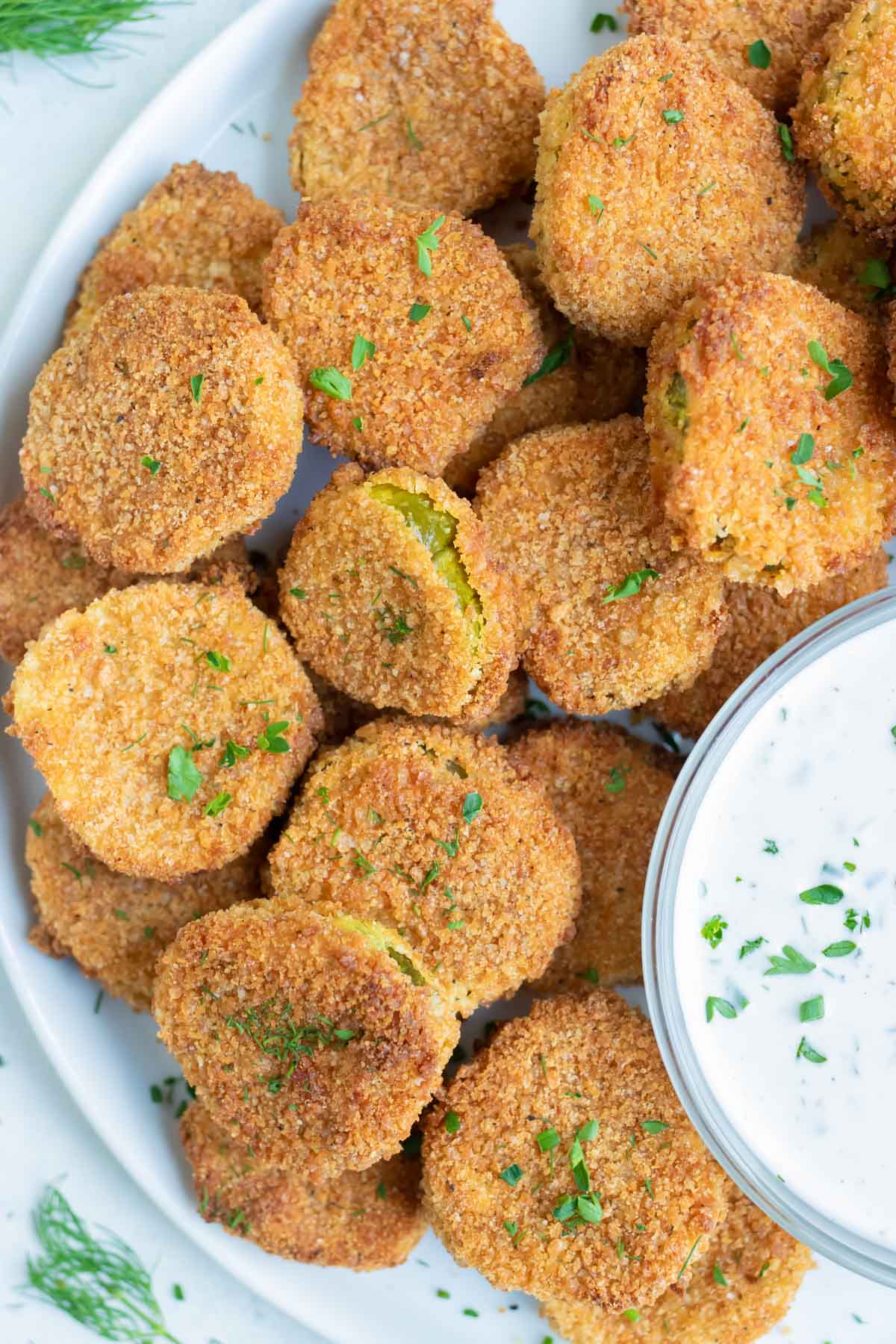 Air Fryer Pickle Chips served on a white plate with a dip on the side.