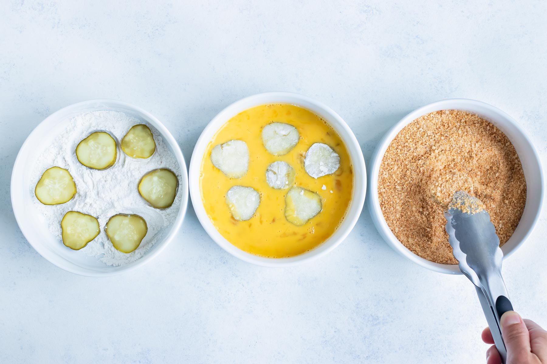 The pickles are coated in flour, egg mixture, and bread crumbs.