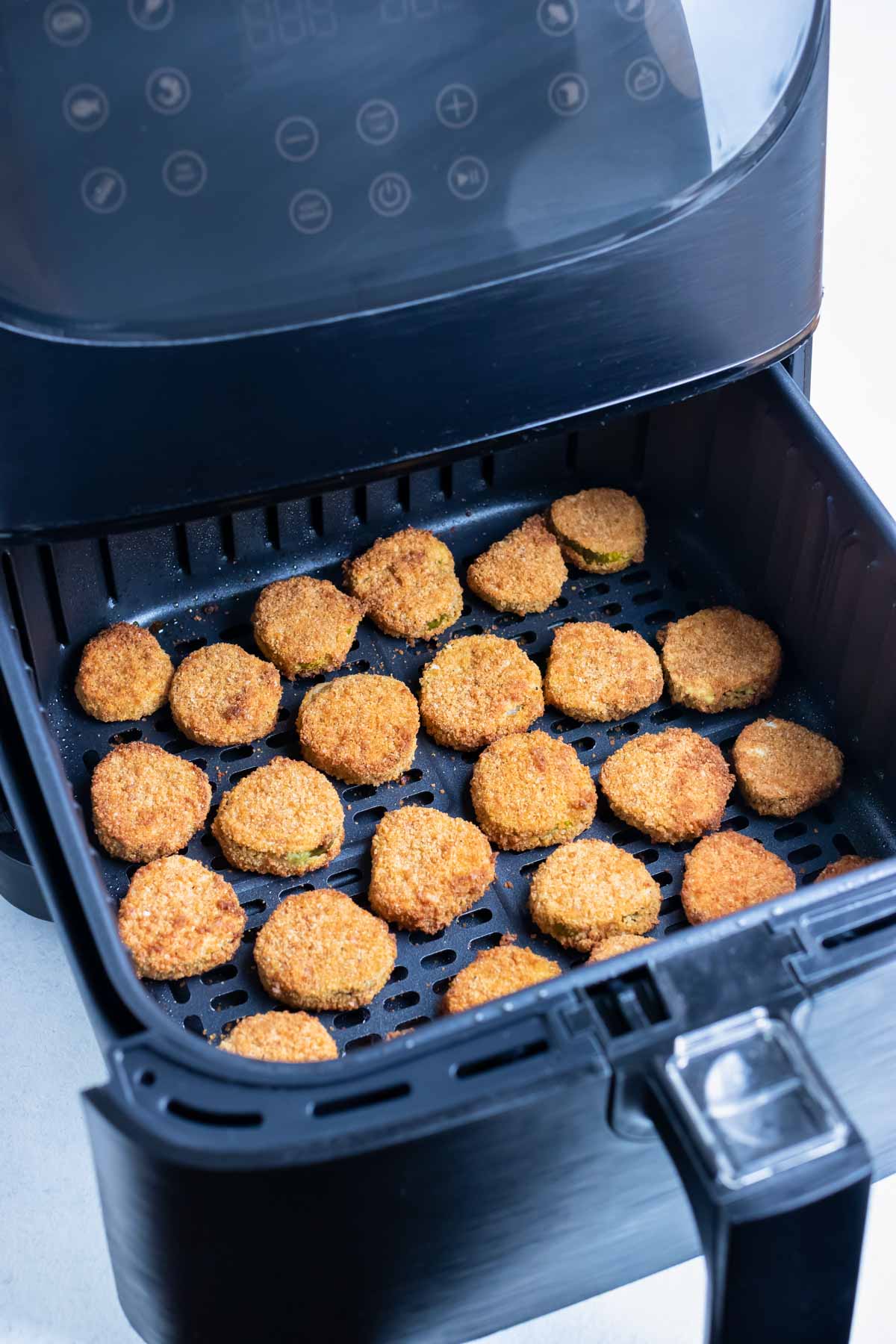 The crispy pickles are cooked in the air fryer until golden brown.