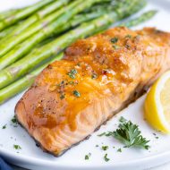 Salmon is served with asparagus and fresh lemon.