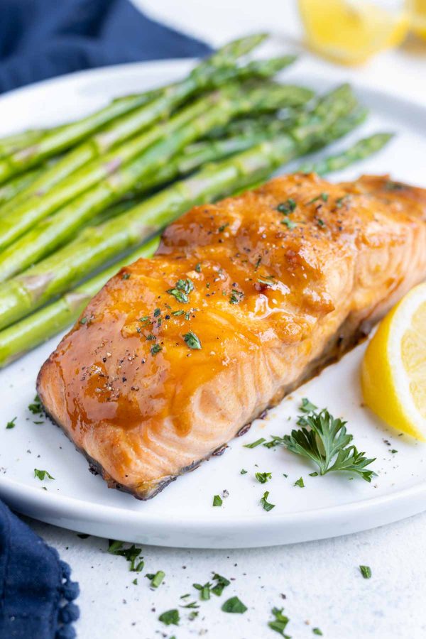 Salmon is served with asparagus and fresh lemon.