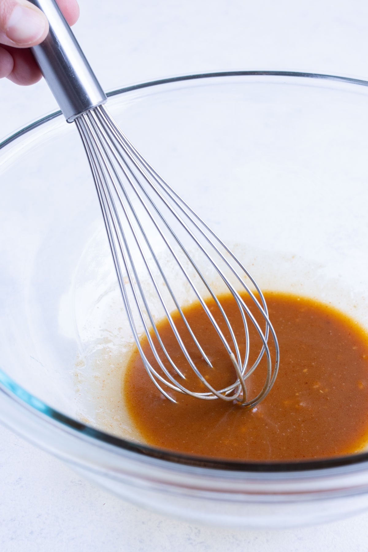 Whisked honey mustard marinade in a glass bowl for salmon in the air fryer.