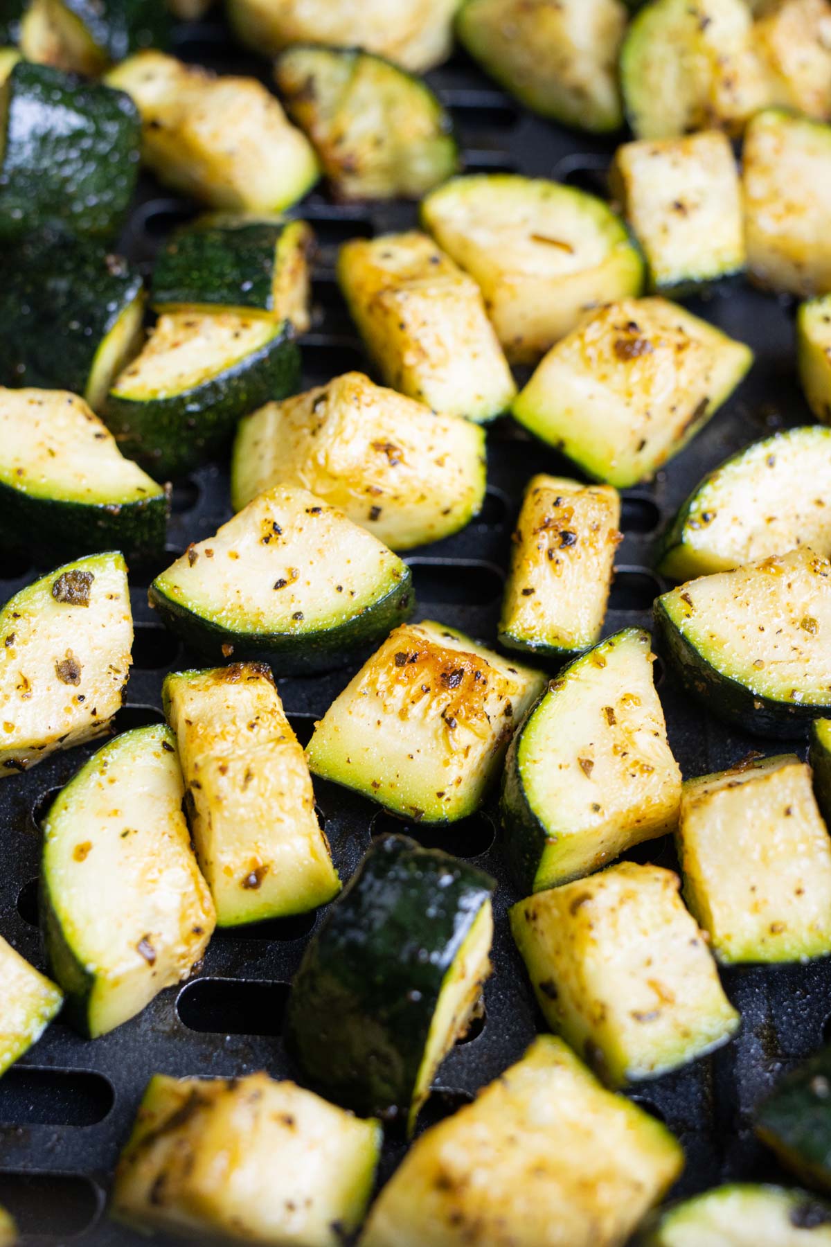 A close up of air fryer zucchini in the basket before cooking.