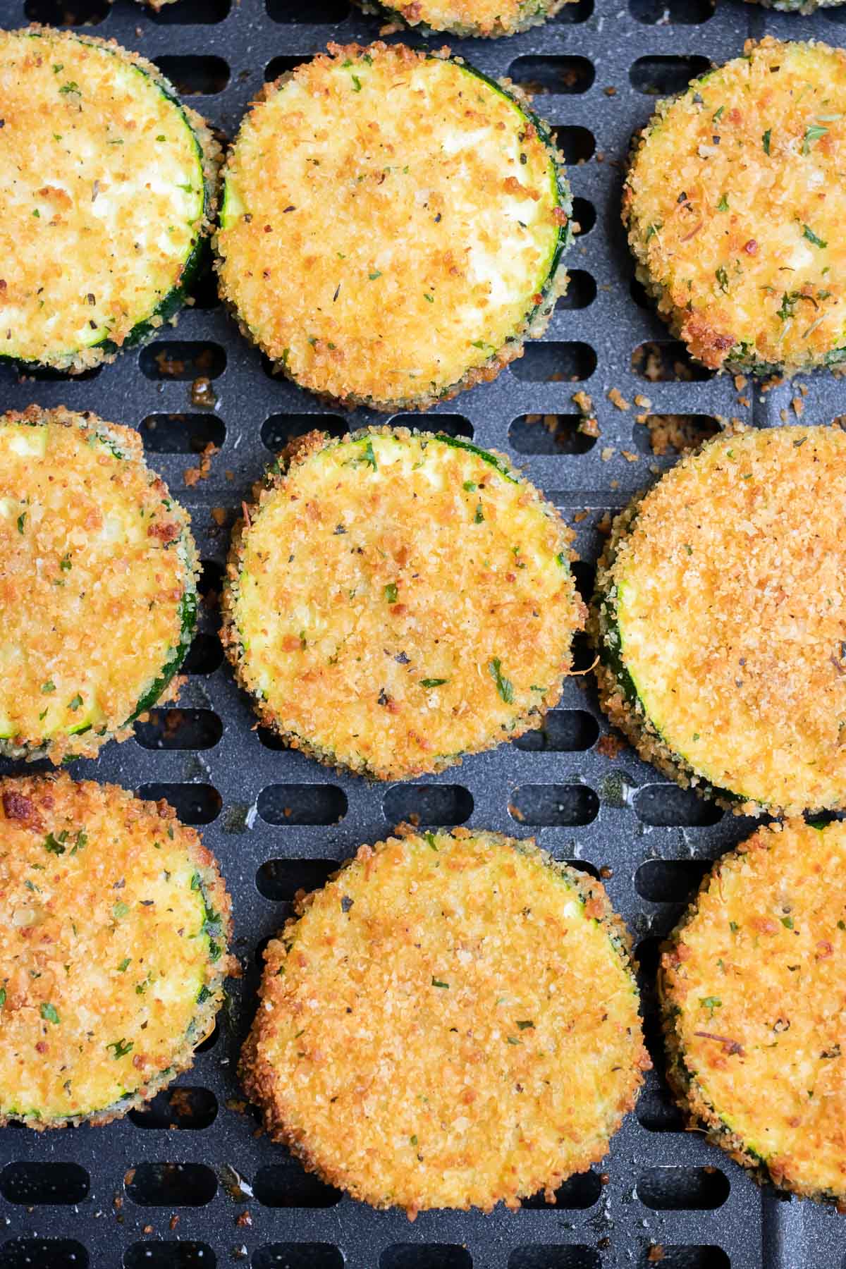 Crispy zucchini chips are shown in the air fryer.