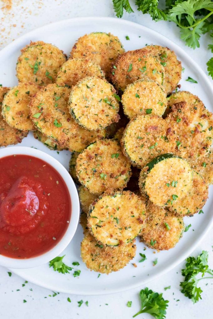 Crispy air fryer zucchini chips served on a white plate.