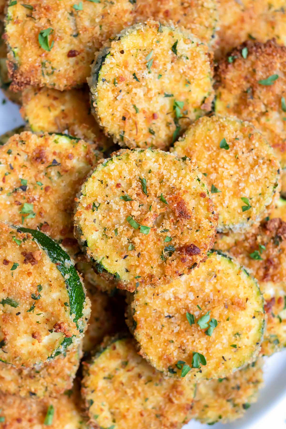 A pile of air fryer zucchini chips are shown for a healthy gluten-free appetizer.