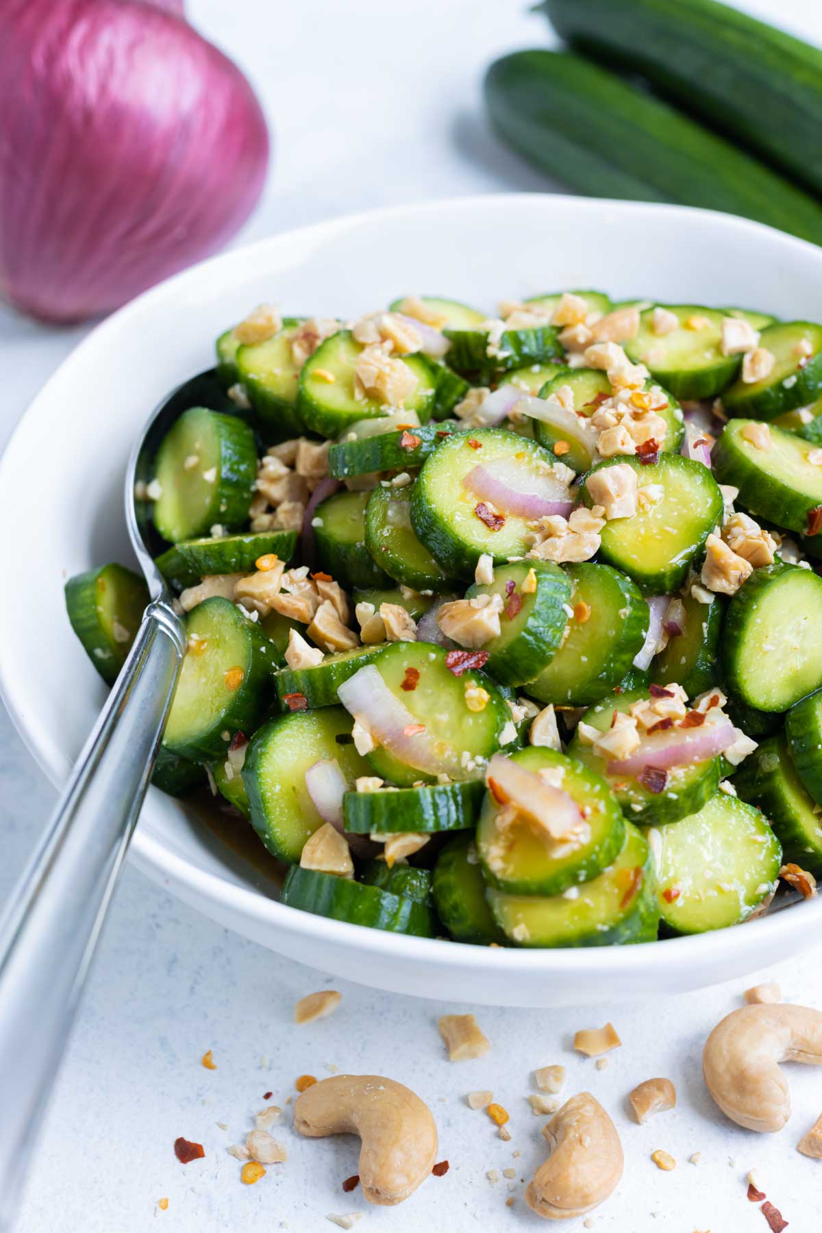 Quick and healthy Asian Cucumber Salad in a glass bowl with a spoon.