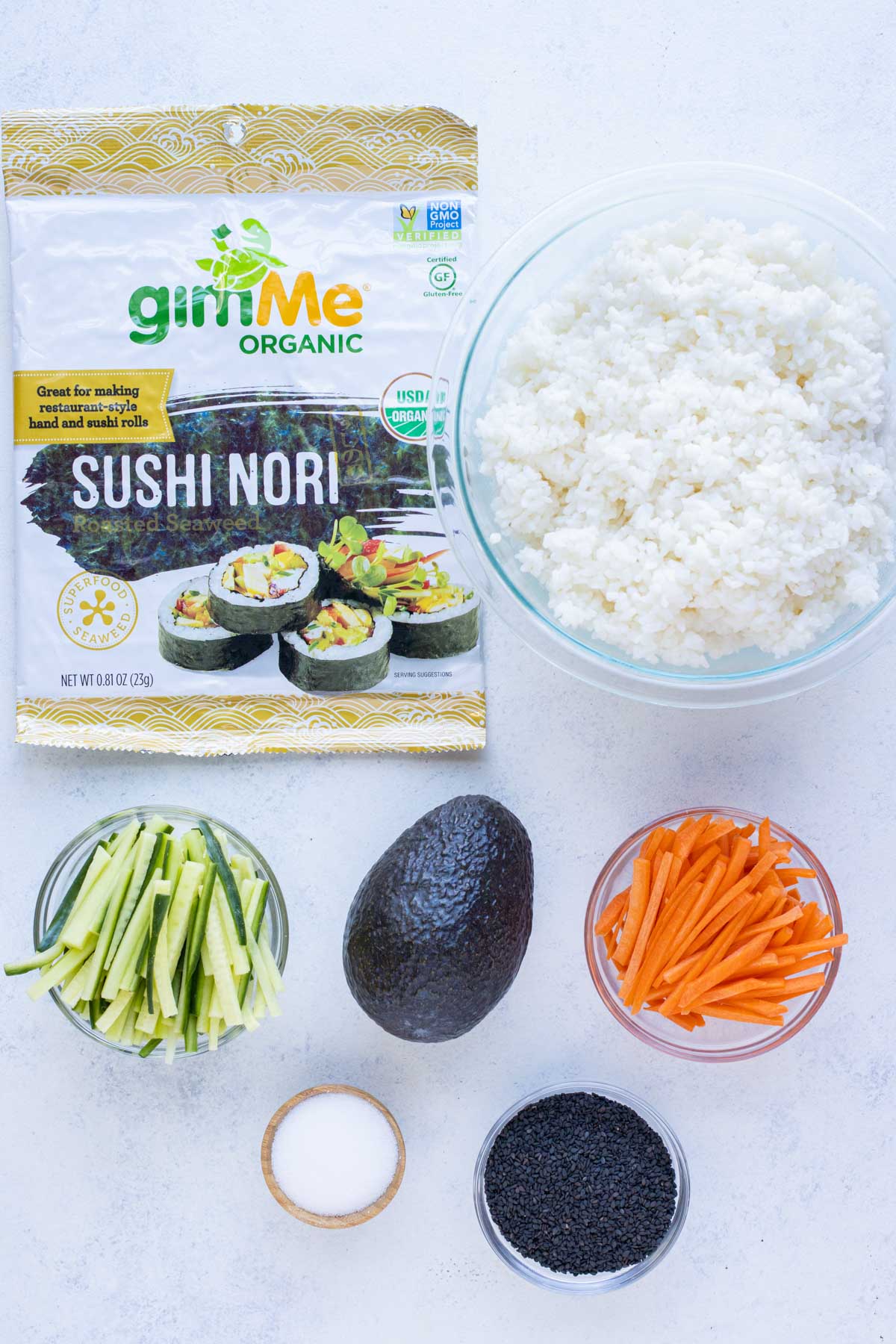 Avocado, rice, carrots, and nori are the ingredients for an avocado roll.