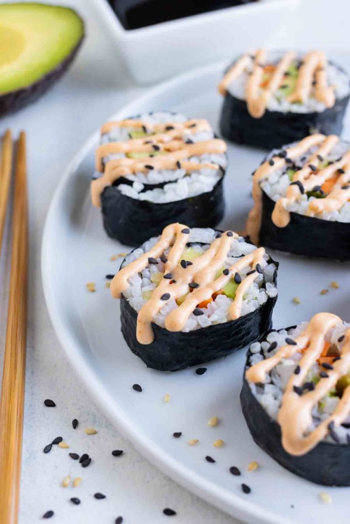 Vegetarian avocado rolls are topped with sesame seeds and sriracha mayo.