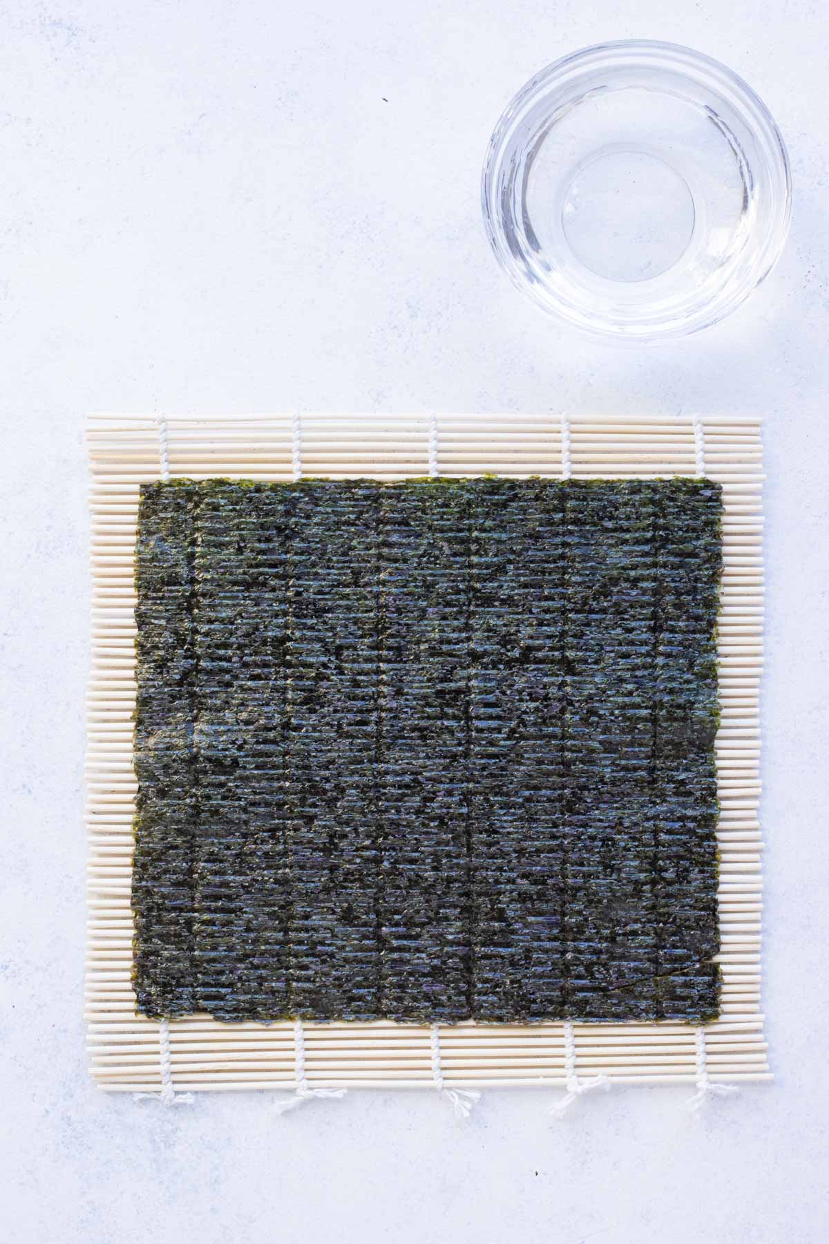 Nori seaweed is placed on a bamboo mat.