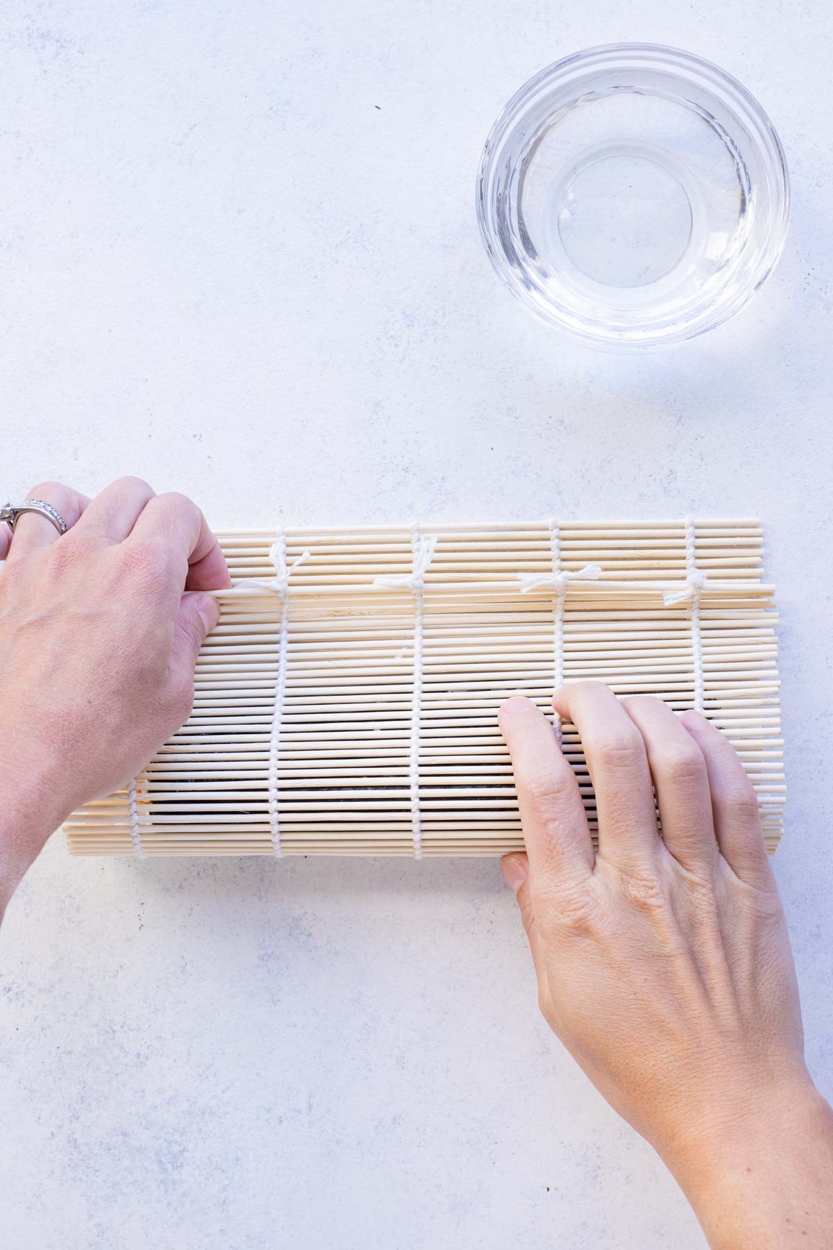 Bamboo mat is used to roll Avocado sushi roll.