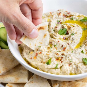 Homemade pita bread is dipped into an eggplant spread.
