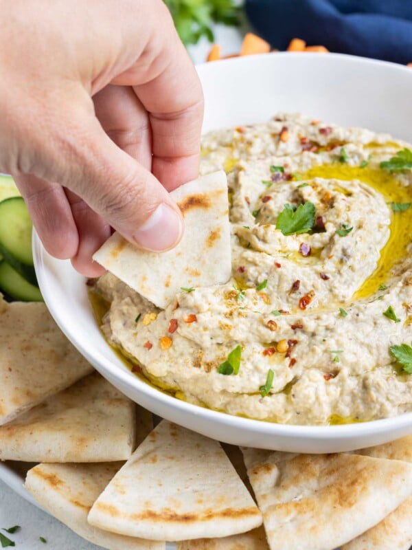 Homemade pita bread is dipped into an eggplant spread.