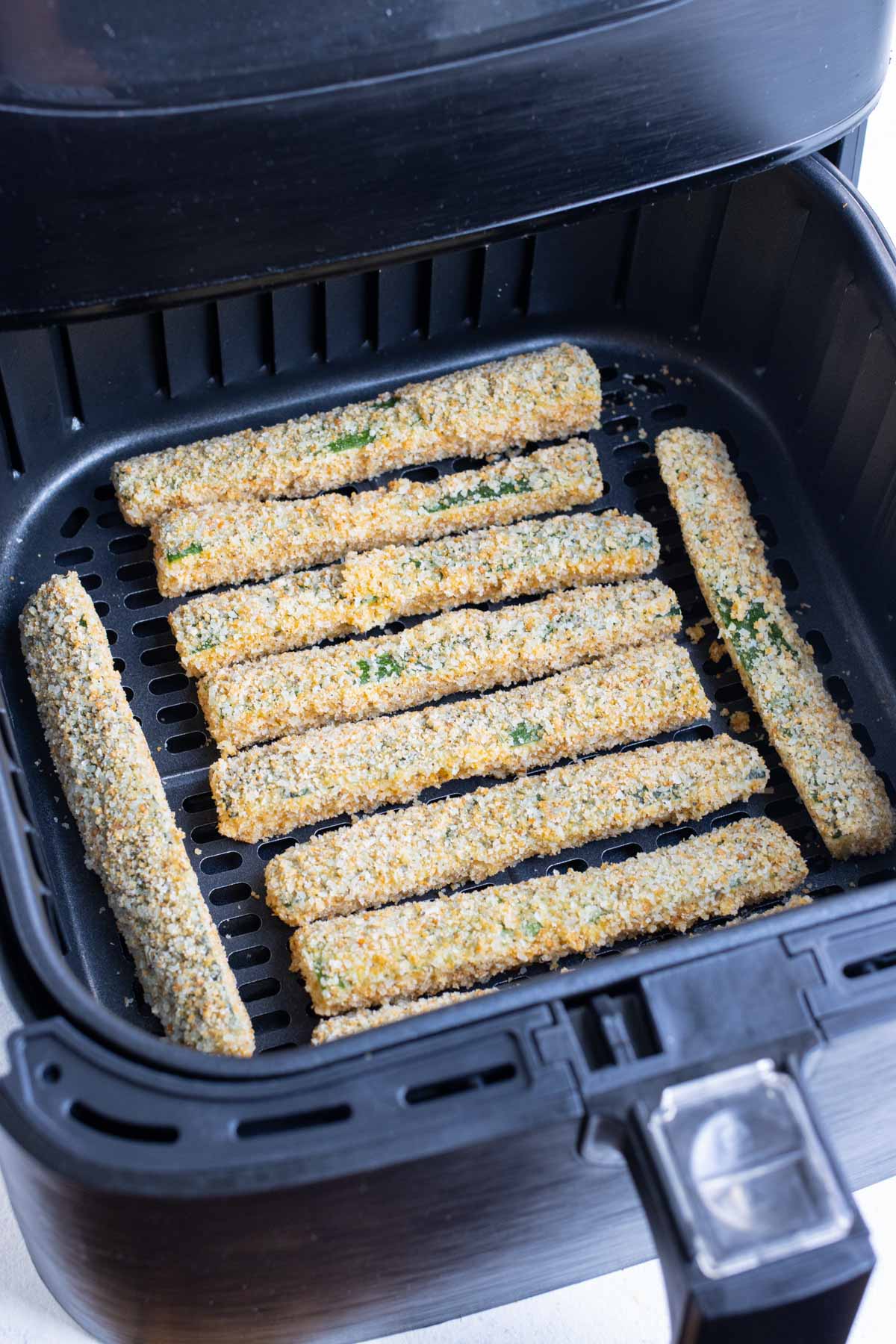 Evenly spaced zucchini in an air fryer.