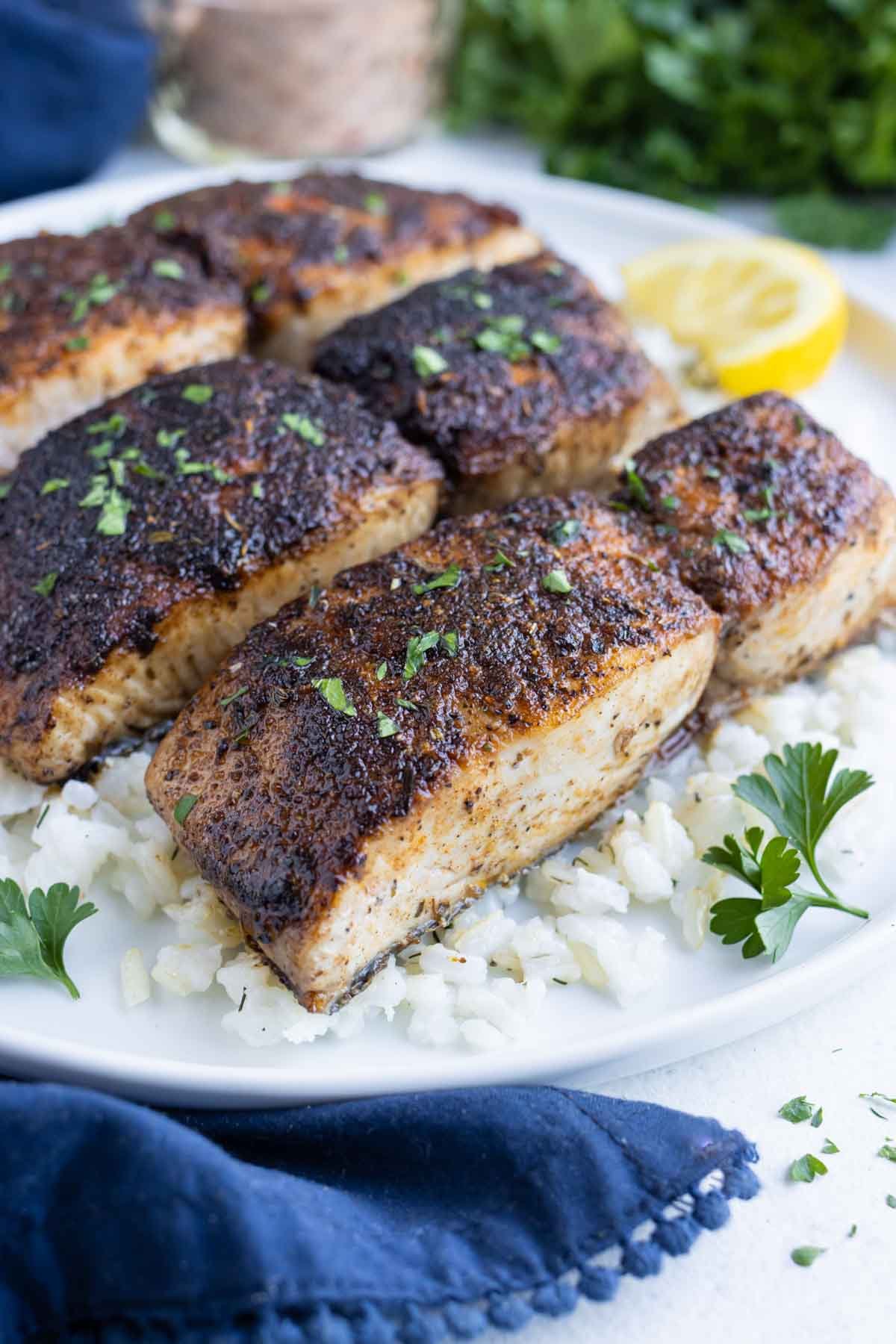 Blackened mahi mahi is served on top of white rice for dinner.