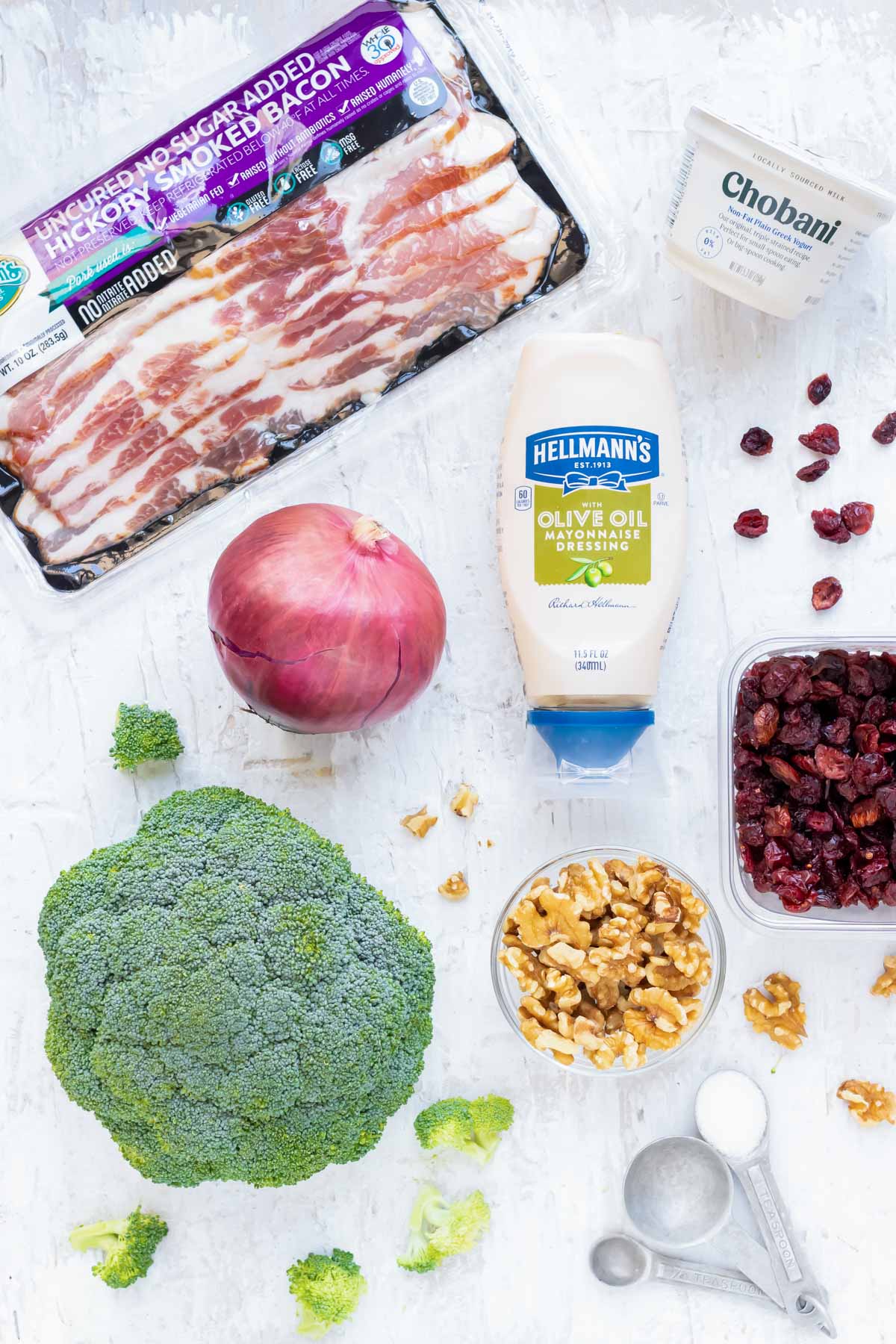 Broccoli, red onion, mayonnaise, Greek yogurt, cranberries, and walnuts as the ingredients in an easy broccoli salad recipe.