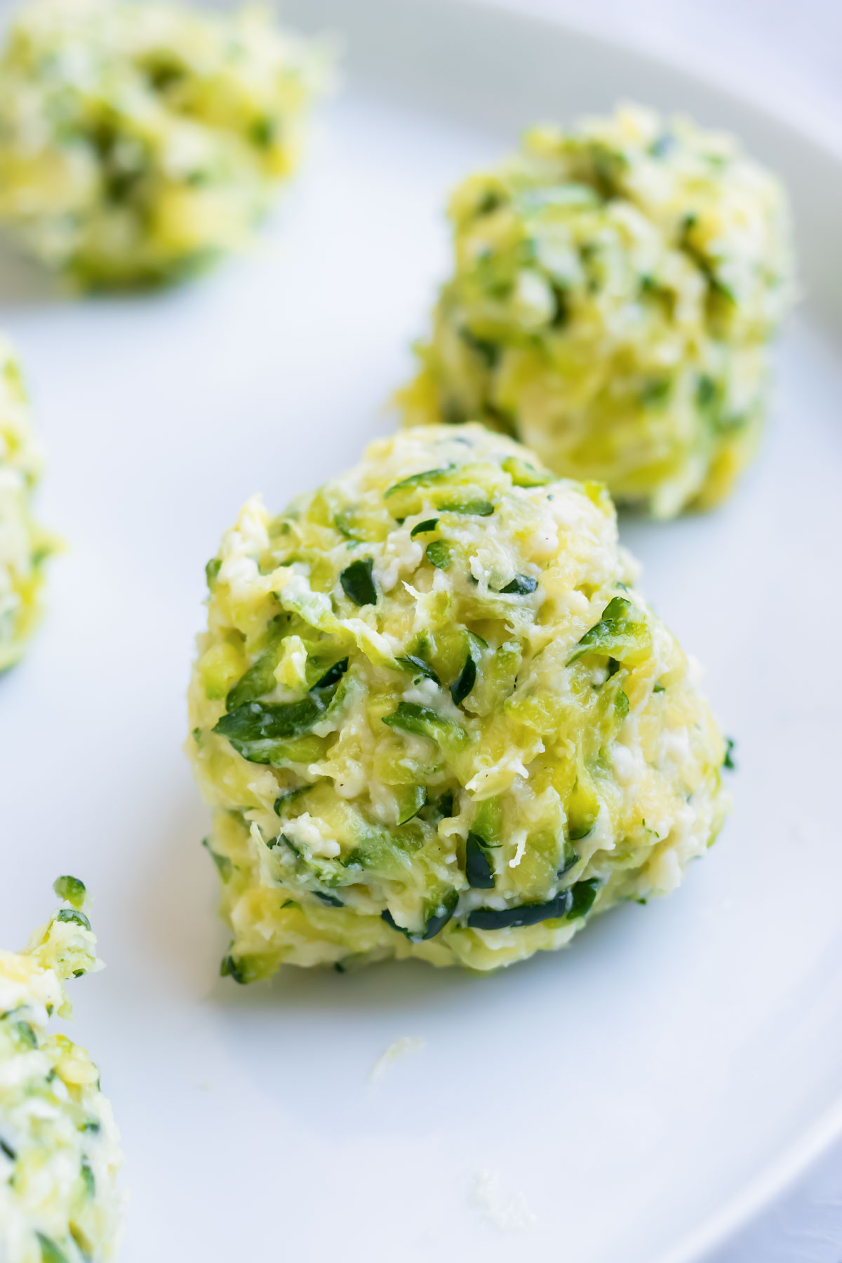 A ball of zucchini and Parmesan cheese for a zucchini fritters recipe.