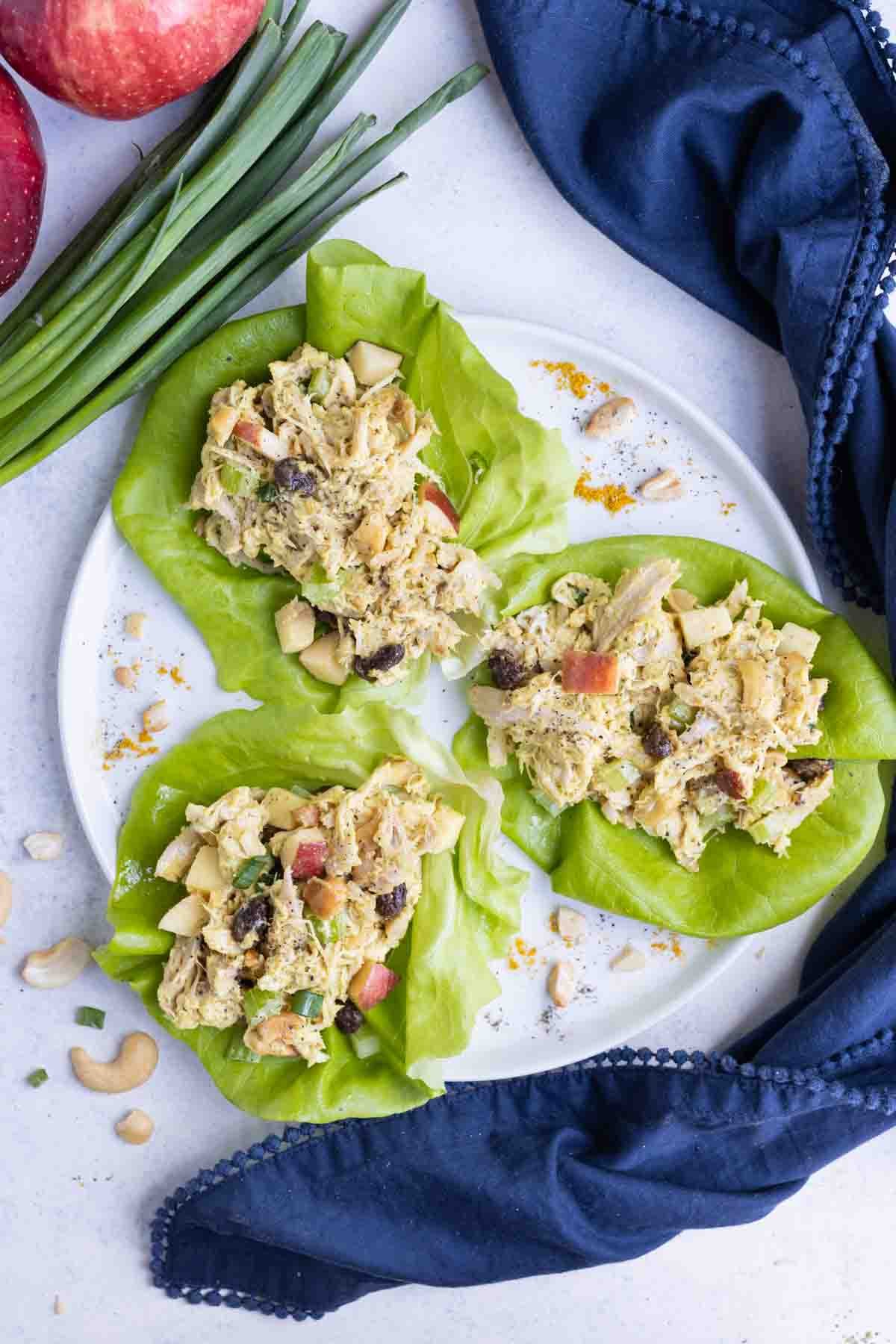 An overhead pictures is used to show curry chicken salad in lettuce on a plate.