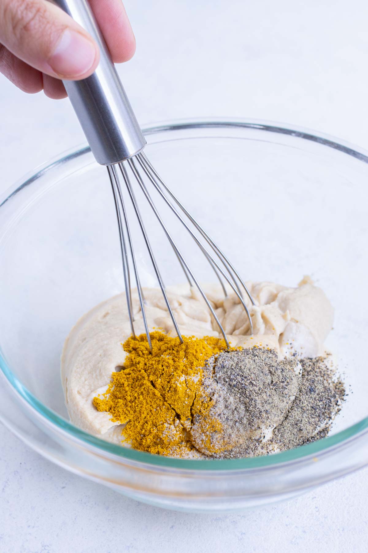 Curry powder, mayonnaise, dijon mustard, salt, and pepper are combined in a bowl.