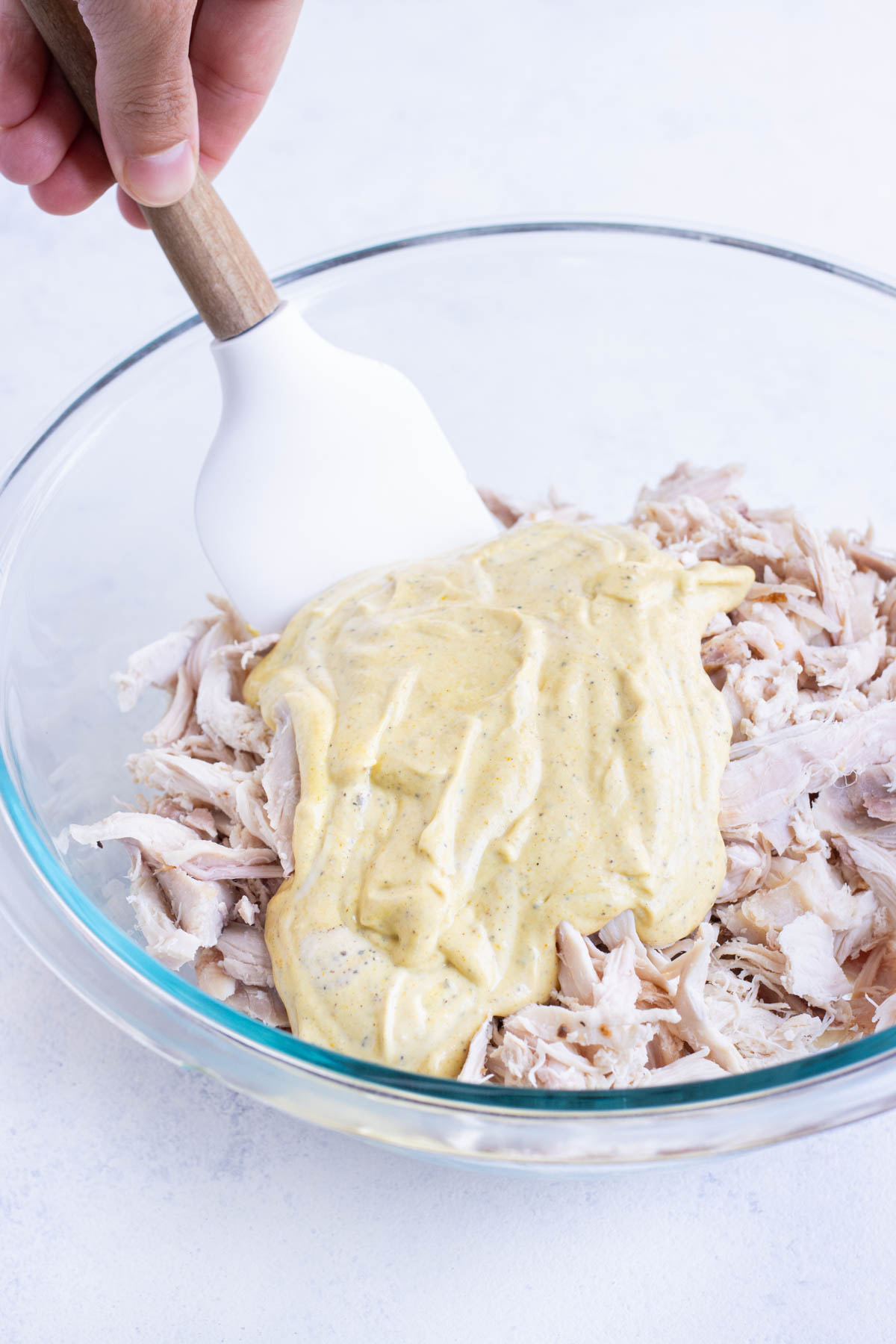 Dressing is added to the shredded chicken.