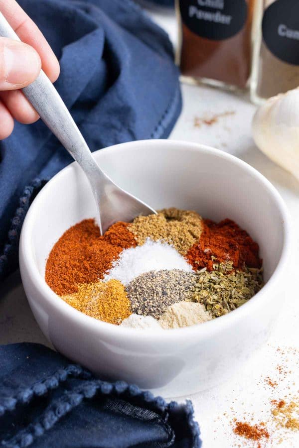 Paprika, chili powder, cayenne powder are some of the ingredients combined in the bowl.