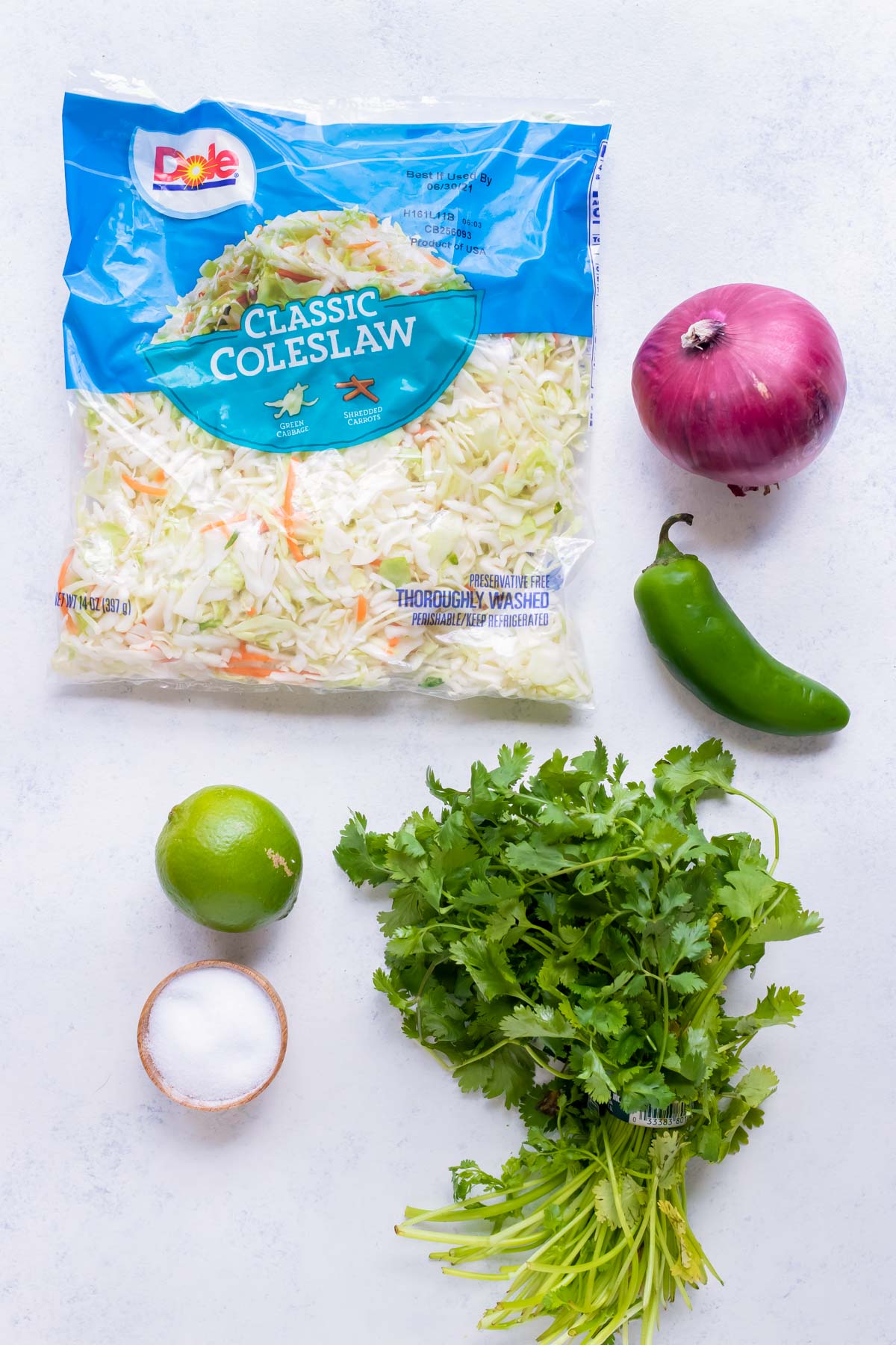 Cabbage mix, red onion, jalapeño pepper, lime, salt, and cilantro are the ingredients for this taco slaw.