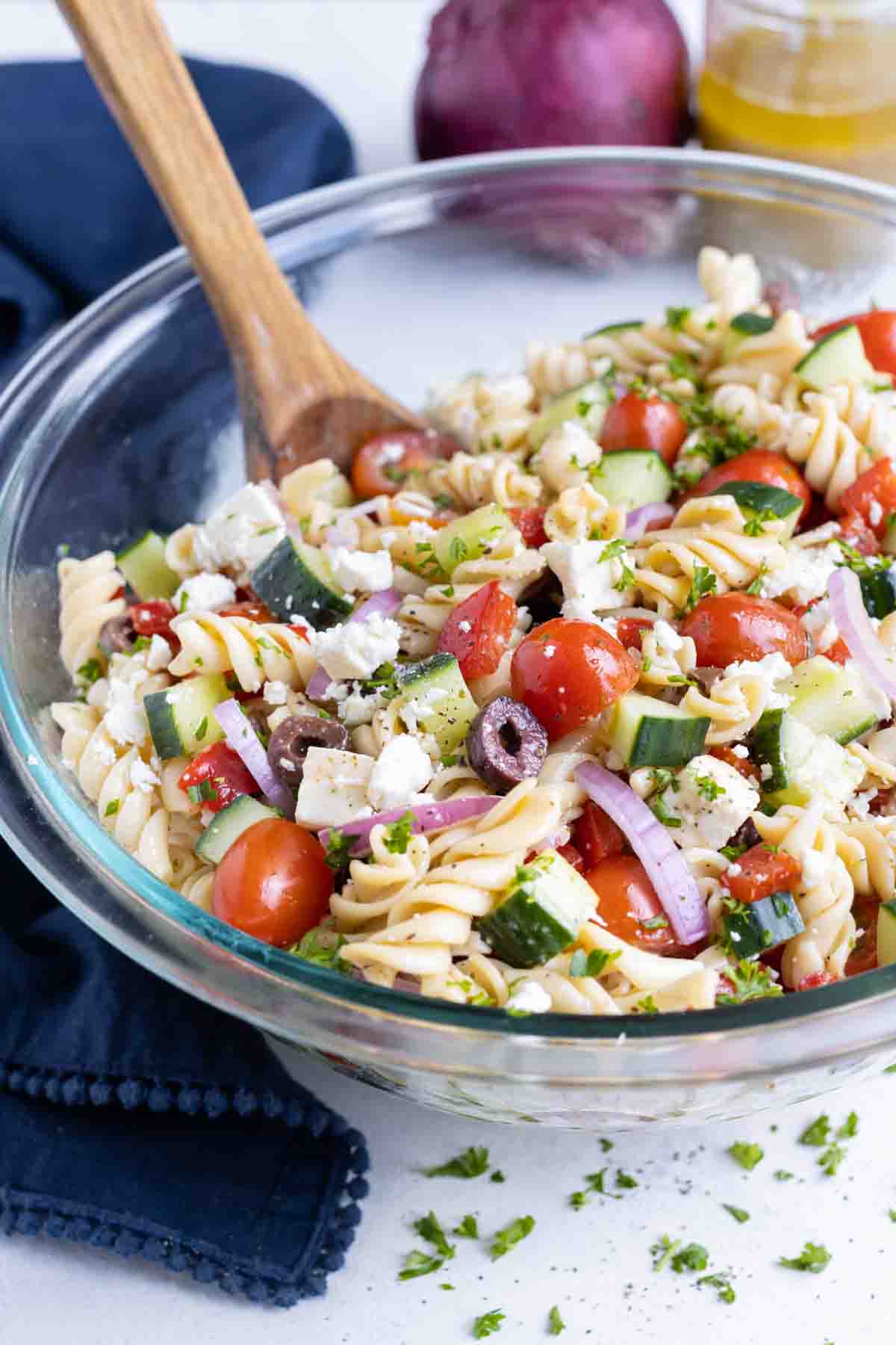 A big bowl of flavorful pasta salad is served for a BBQ side dish.
